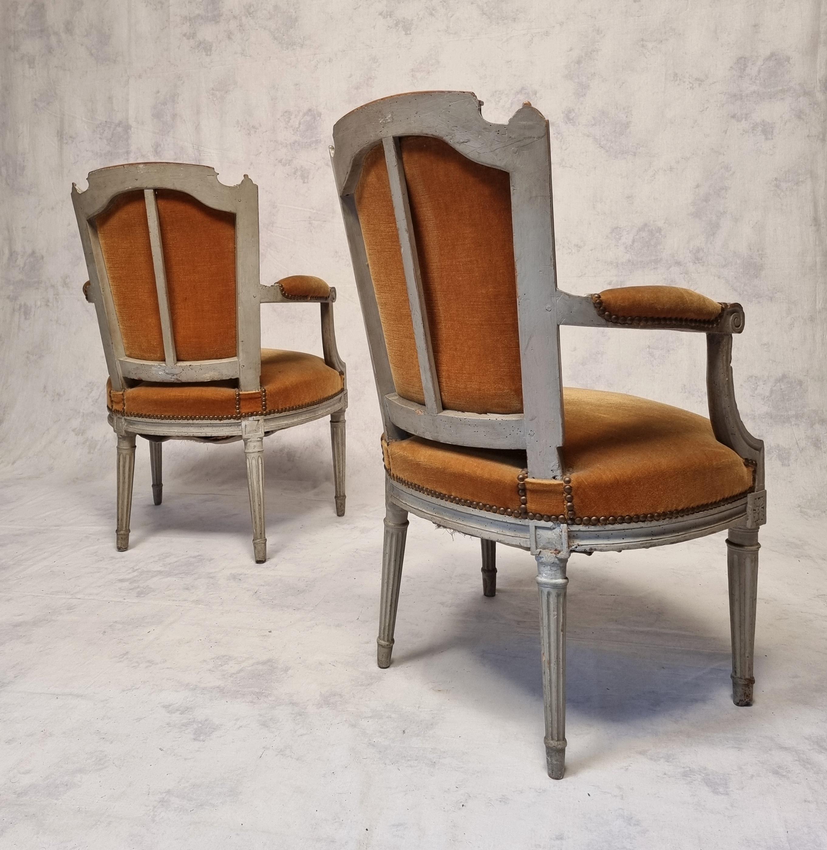 Paire de fauteuils cabriolets avec dossier en chapeau de gendarme, époque Louis XVI. Ces fauteuils sont en bois laqué d'origine. Elles datent de la fin du XVIIIe siècle, vers 1785. Ils ont de belles moulures. Les pieds sont effilés et cannelés.