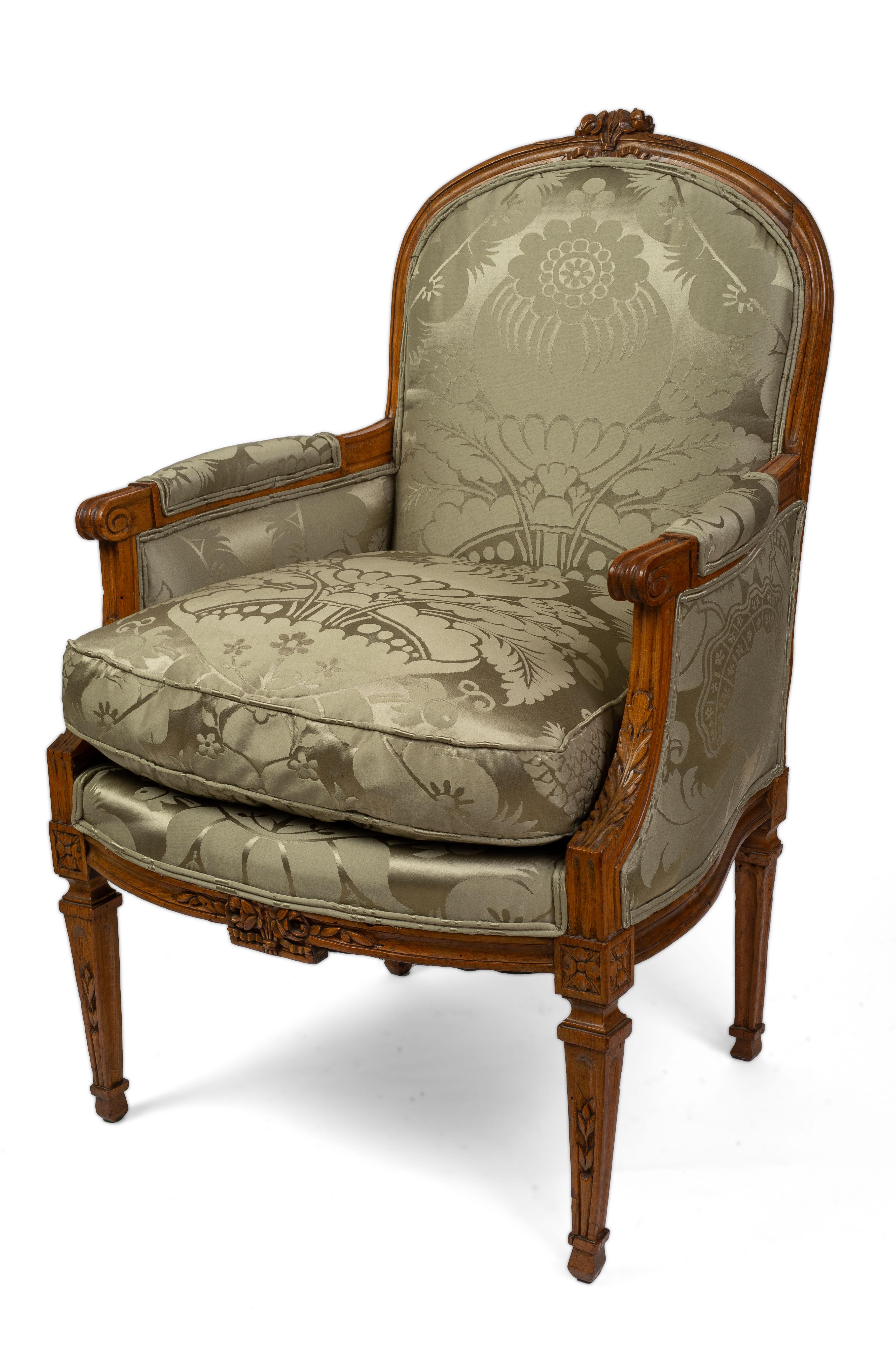 Each arched back with a bow-tied ribbon crest repeated on the front rail with issuing laurel leaves, with the padded back, sides and loose down-filled cushion upholstered in vintage silk damask fabric with foliate motif, over a bowed carved seat