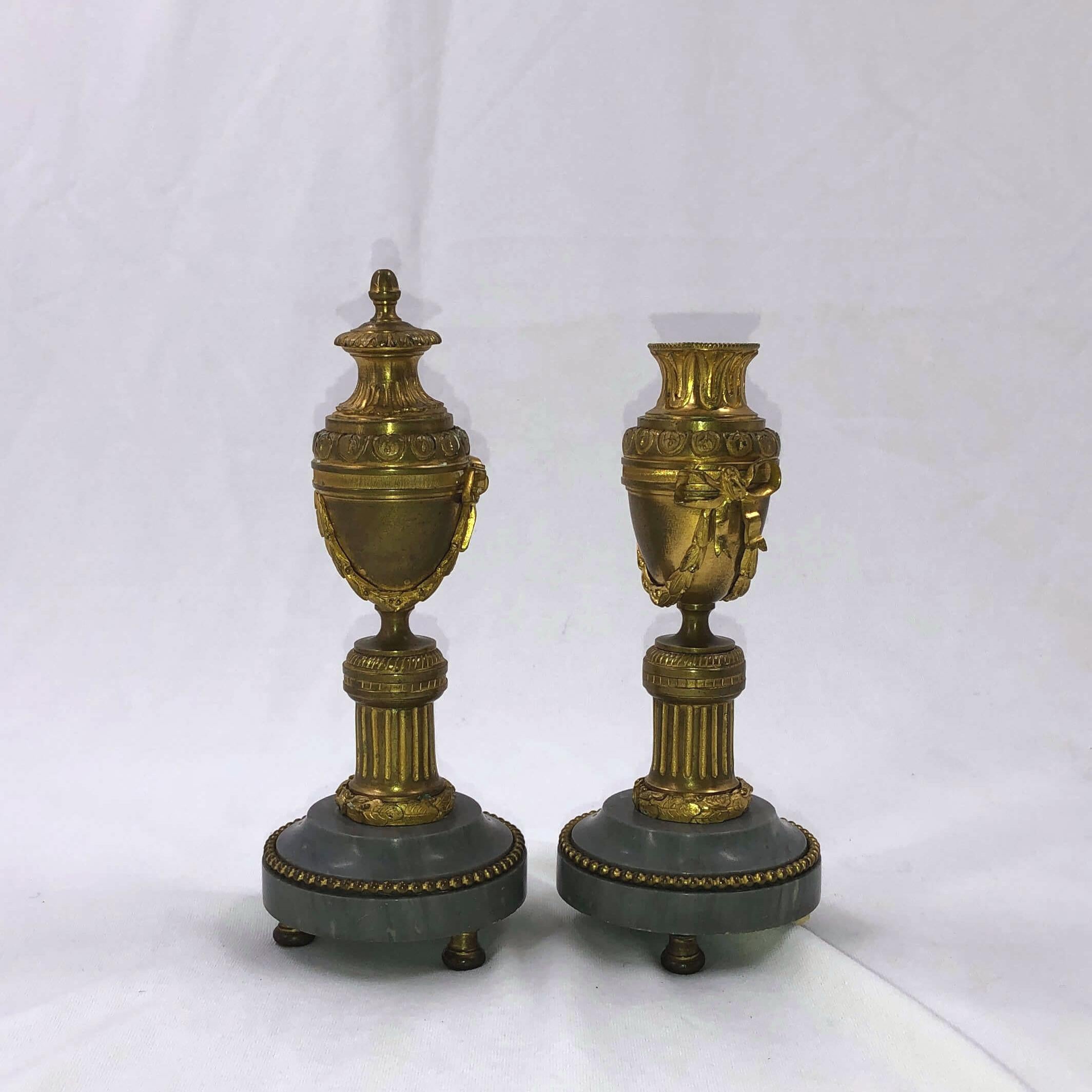 A fine pair of French bronze doré Cassollette with urn form chased acanthus leaves bowknots garlands and a fluted pillar and raised on a round grey marble base having a beaded bronze edge.