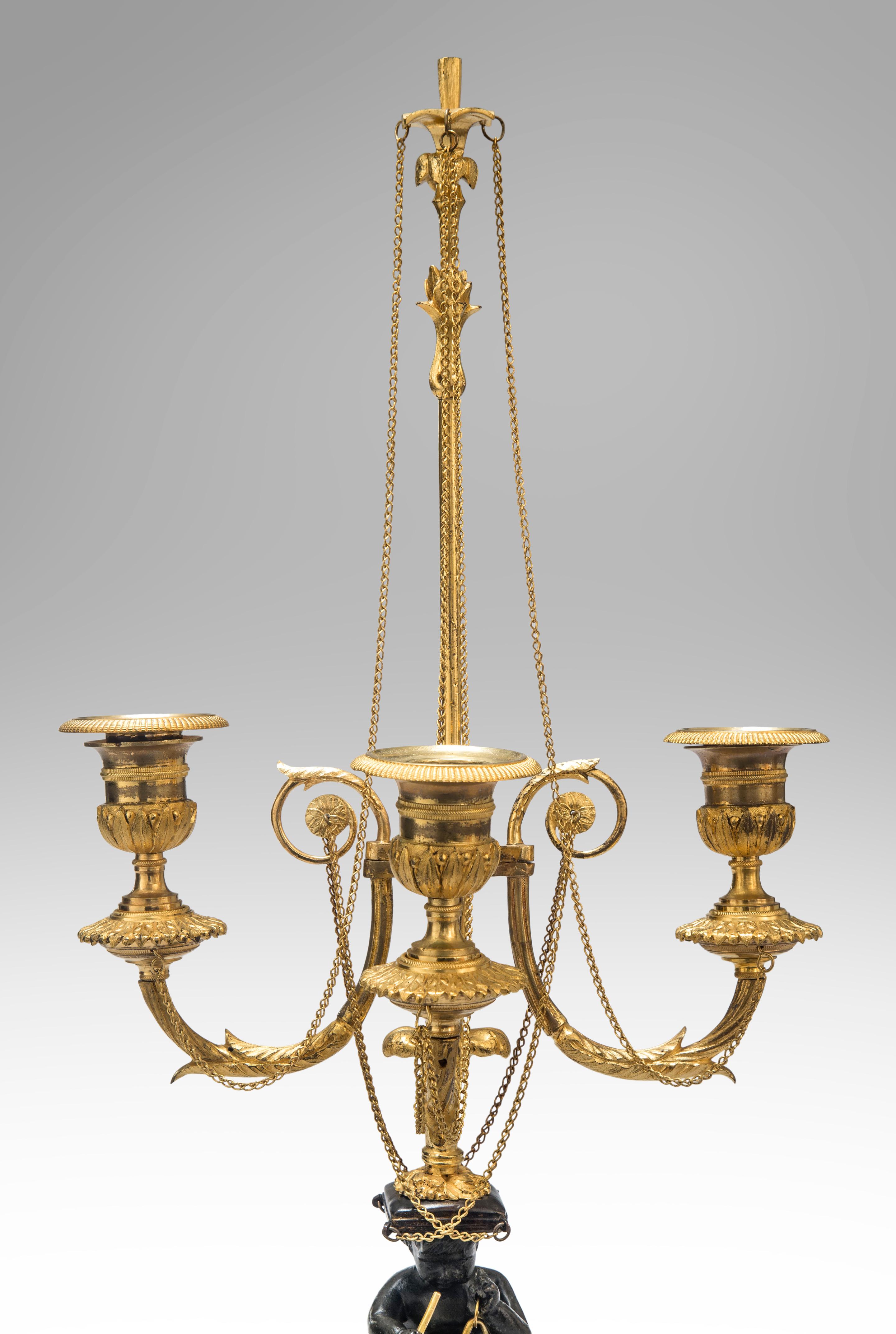 A pair of Louis XVI candelabra
Late 18th century
An extraordinary pair of the finest quality candelabra, crisply detailed, and with lovely gilding of a restrained yet sumptuous color. Each with a patinated bronze putto triton seated on a sleigh