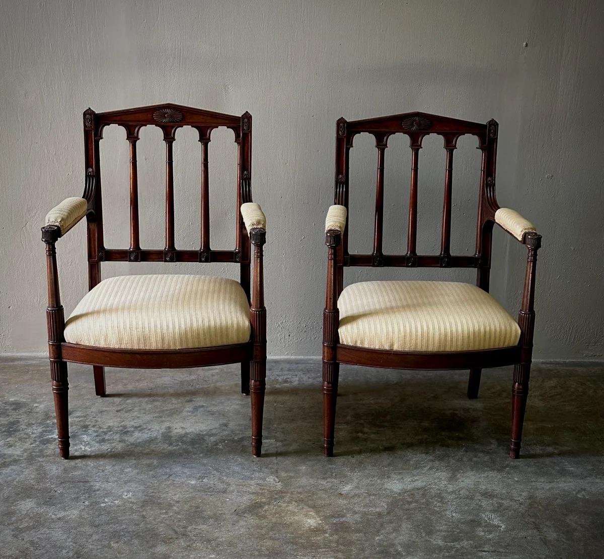 Questa squisita coppia di fauteuil in stile Luigi XVI, attribuita al celebre artigiano Georges Jacob durante il regno di Napoleone I, mette in mostra la precisione dell'artigianato classico francese. Intagliate a mano in mogano, queste sedie sono