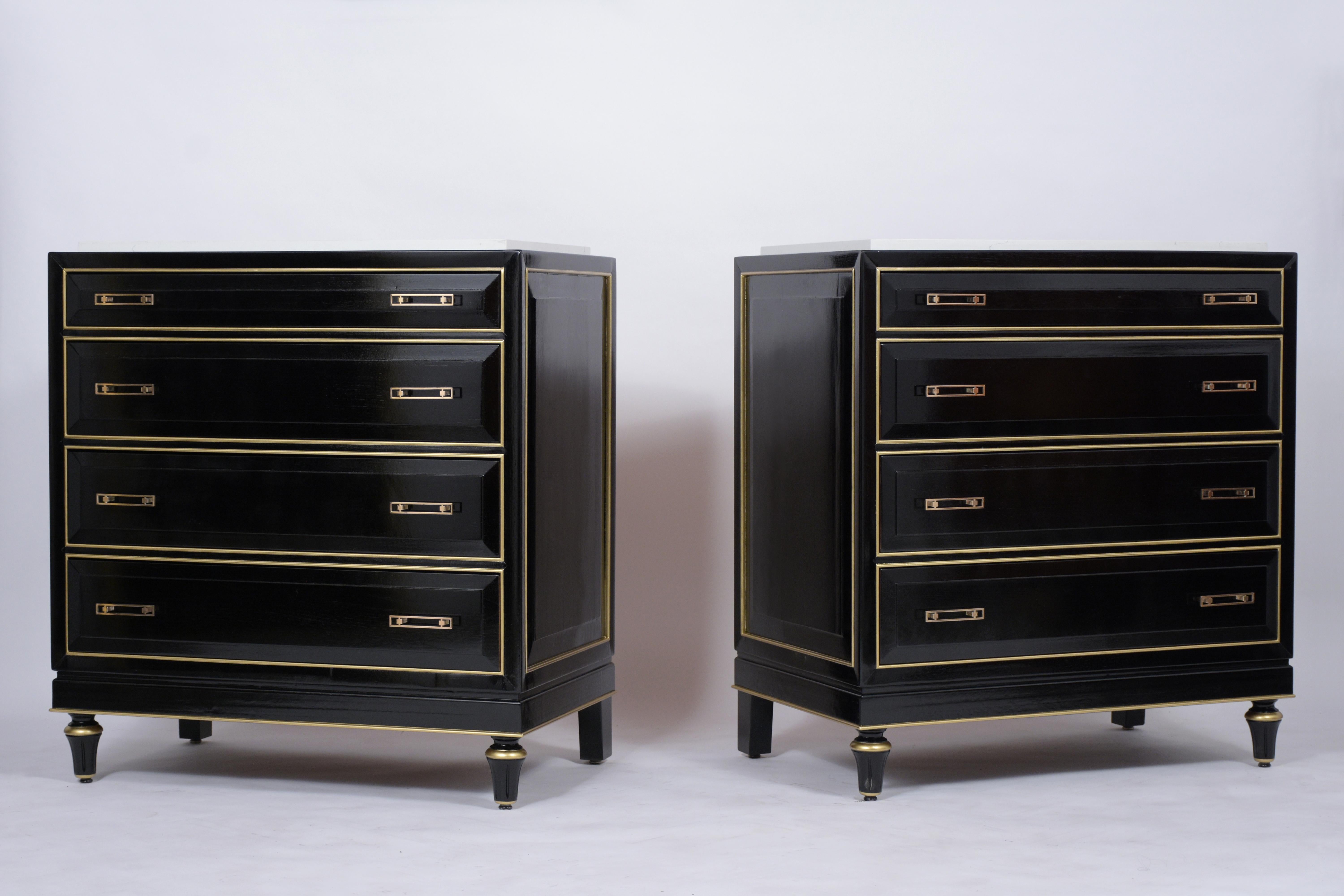 A fabulous pair of Louis XVI style chest of drawers which is handcrafted out of mahogany wood with a new ebonized lacquered finish and has been professionally restored. This pair of dressers features a marble top, gilt molding accents, and four