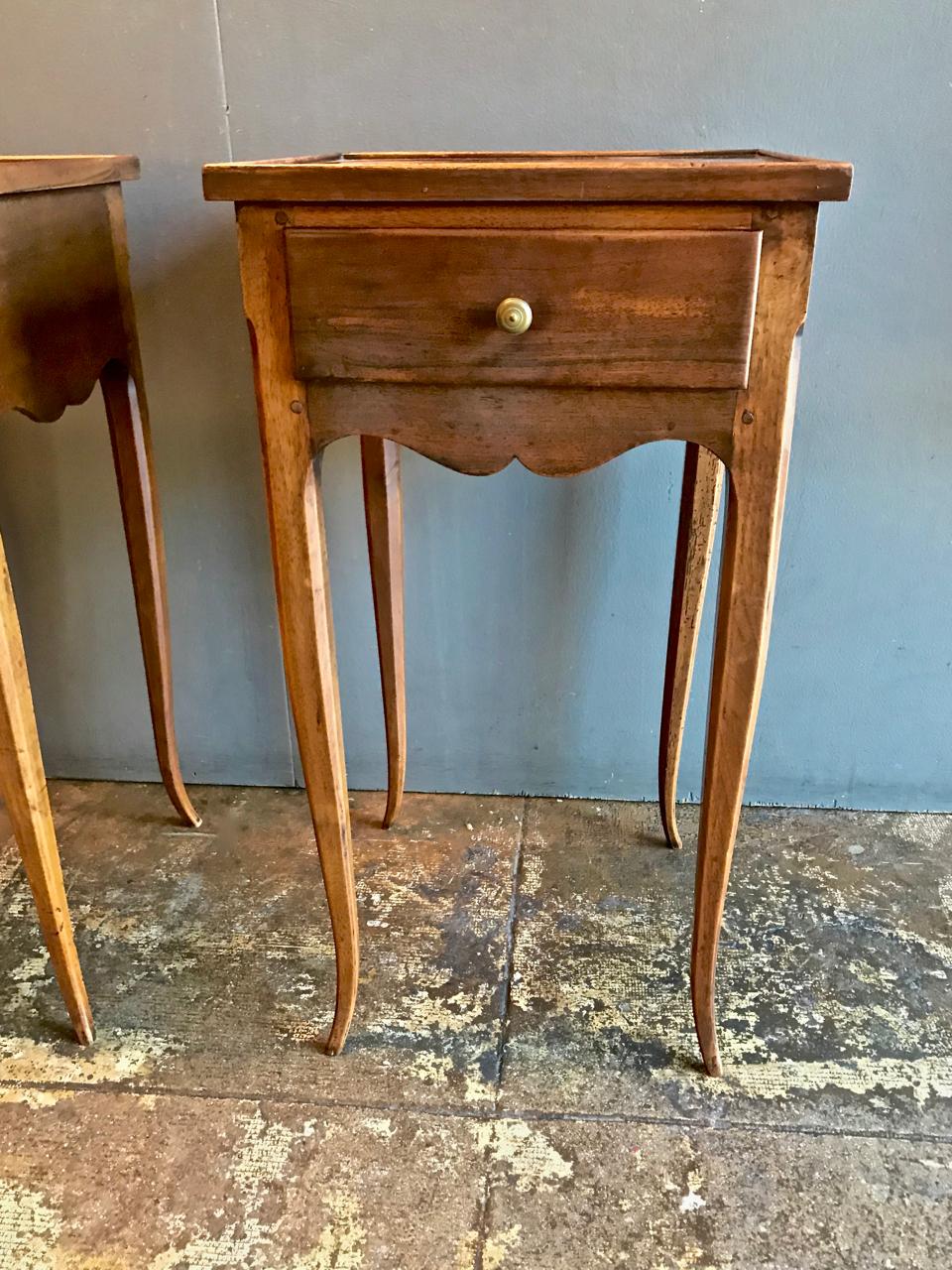 This is a very hard-to-find pair of French Provincial petites commodes. The commodes feature solid walnut construction, pegged joinery, dovetailed drawers, serpentine skirts and charming sexy curvy legs. Additionally, the tops feature a small raised