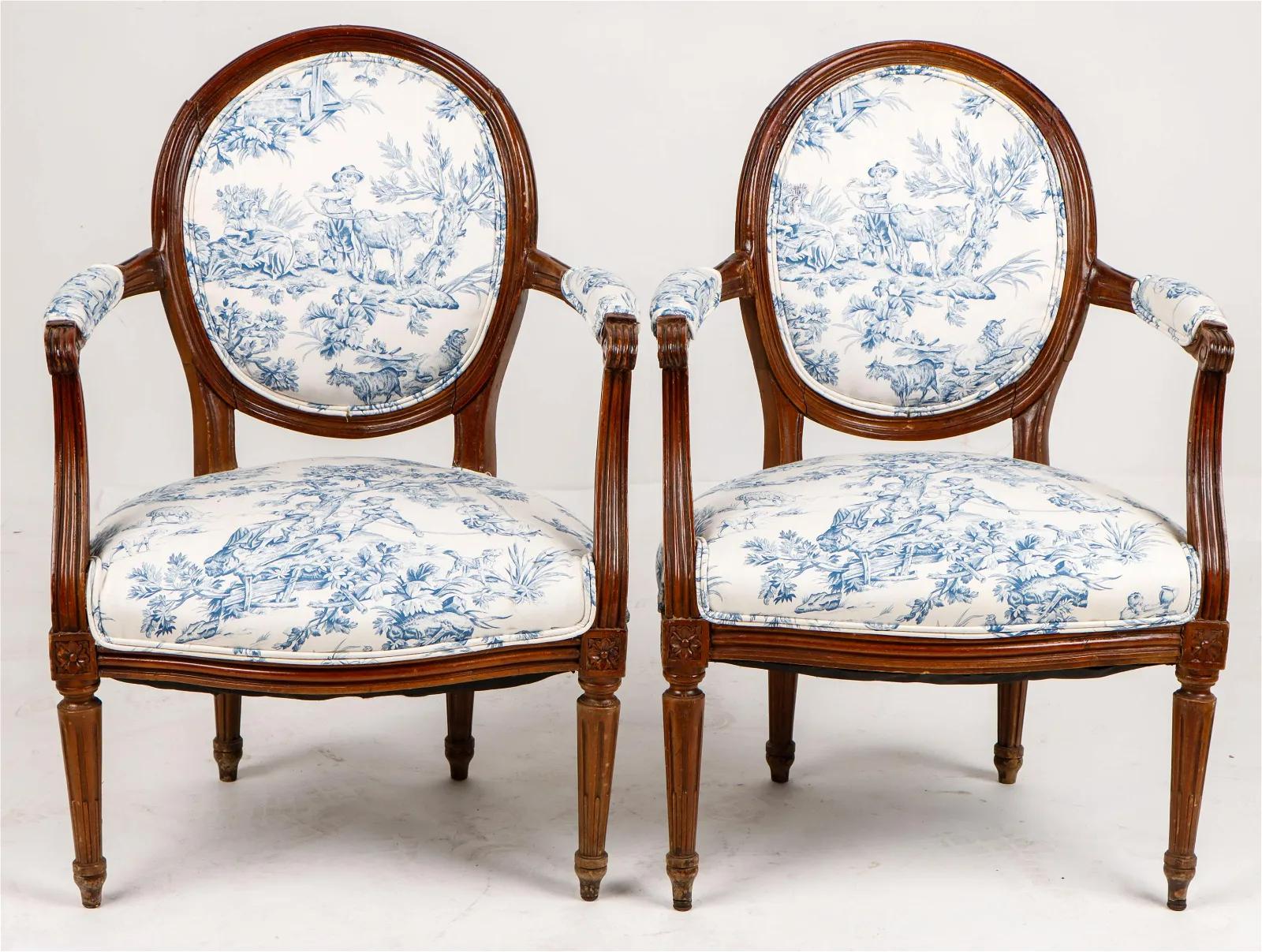 A pair of Louis XVI fauteuils in dark stained beech, with round backs and straight tapered and fluted legs, recently upholstered in blue and white toile de jouy fabric.