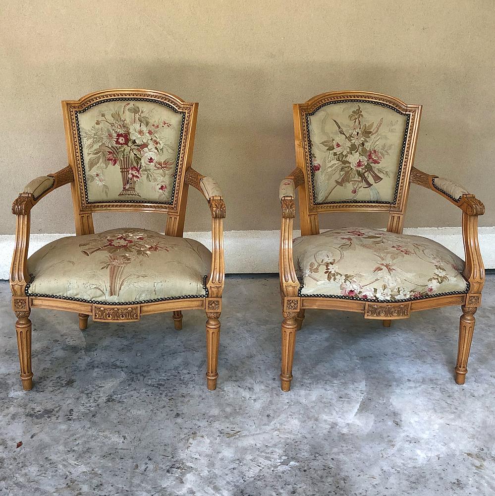 Pair of Louis XVI French Aubusson Tapestry Fruitwood Armchairs was handcrafted from solid apple wood in one of the more intriguing interpretations of the Louis XVI style. This pair of armchairs retain the light, warm tones of the wood, hand-carved
