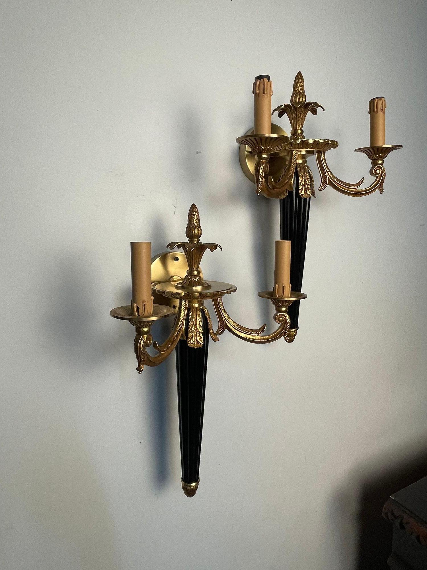 Pair of Louis XVI French Style Wall Sconces, Bronze, Ebony, Hollywood Regency, In the Manner of Maison Bagues

A strickingly well crafted pair of stylish wall sconces each having bronze adornments with a reeded ebony column center. The pair having
