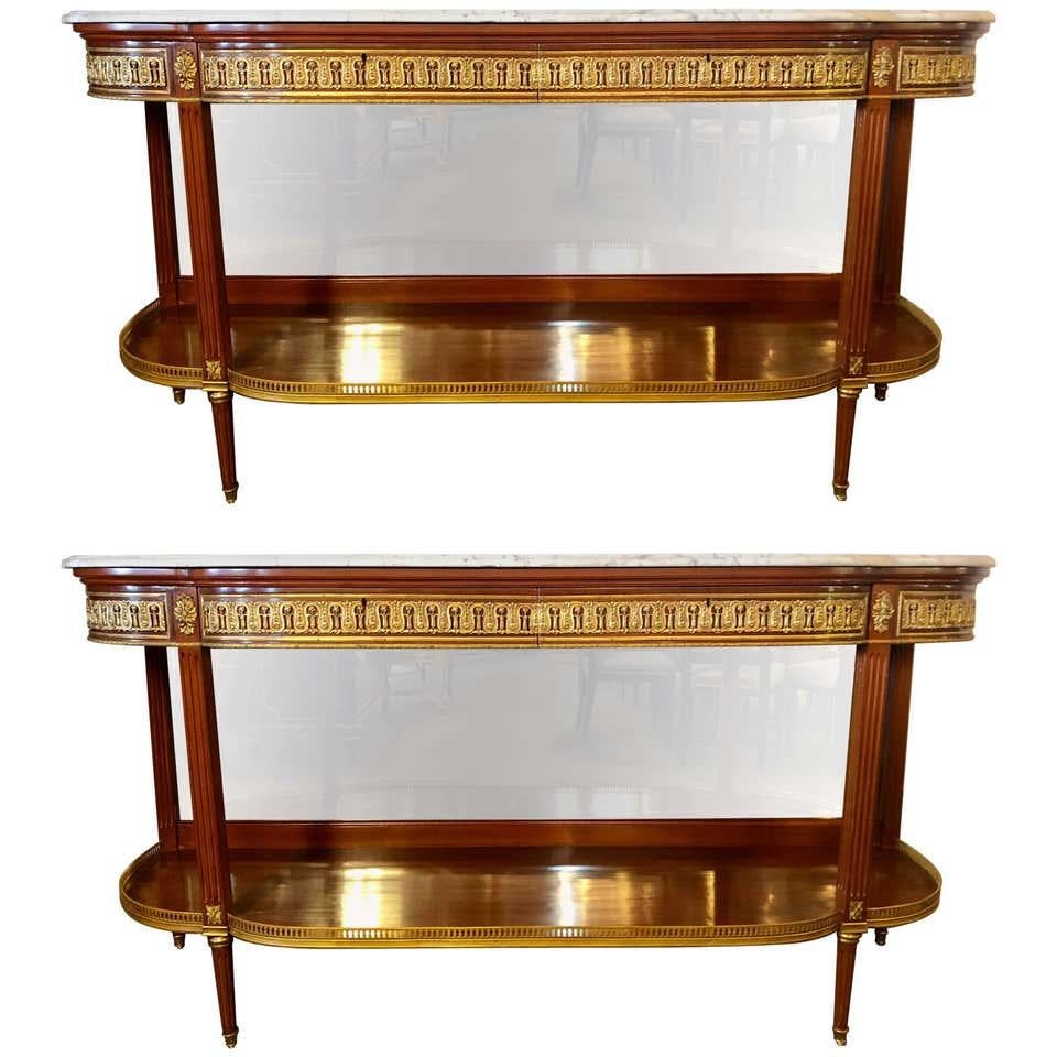 A fine pair of Louis XVI Jansen style marble-top console tables or sideboards with bevel mirror back panels. This pair of Maison Jansen style demilune form console tables are not only impressive in size but the custom quality is second to none.