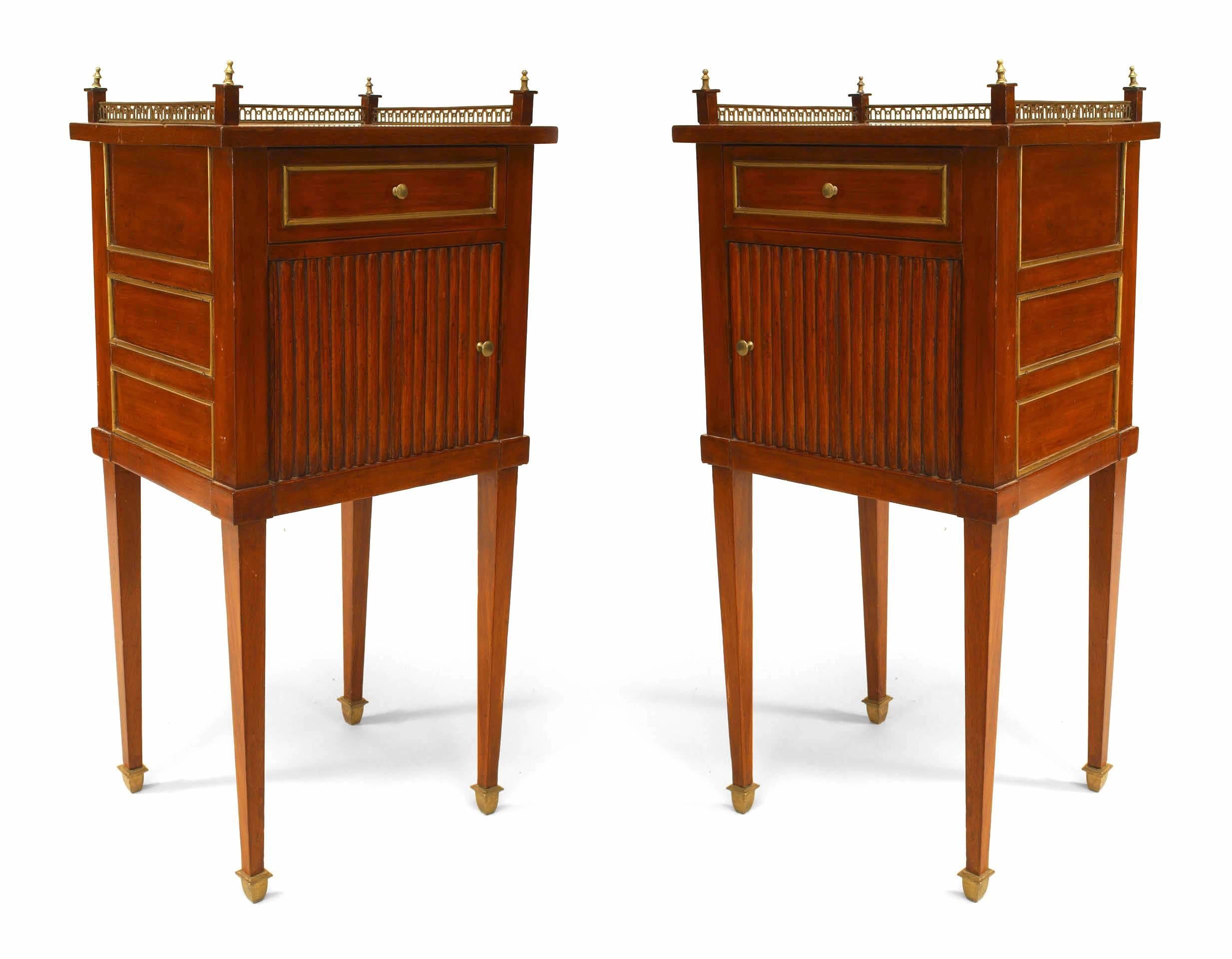 Pair of rectangular Louis XVI mahogany bedside commodes each with a fluted door beneath a single drawer and a brass gallery top with corner finials.