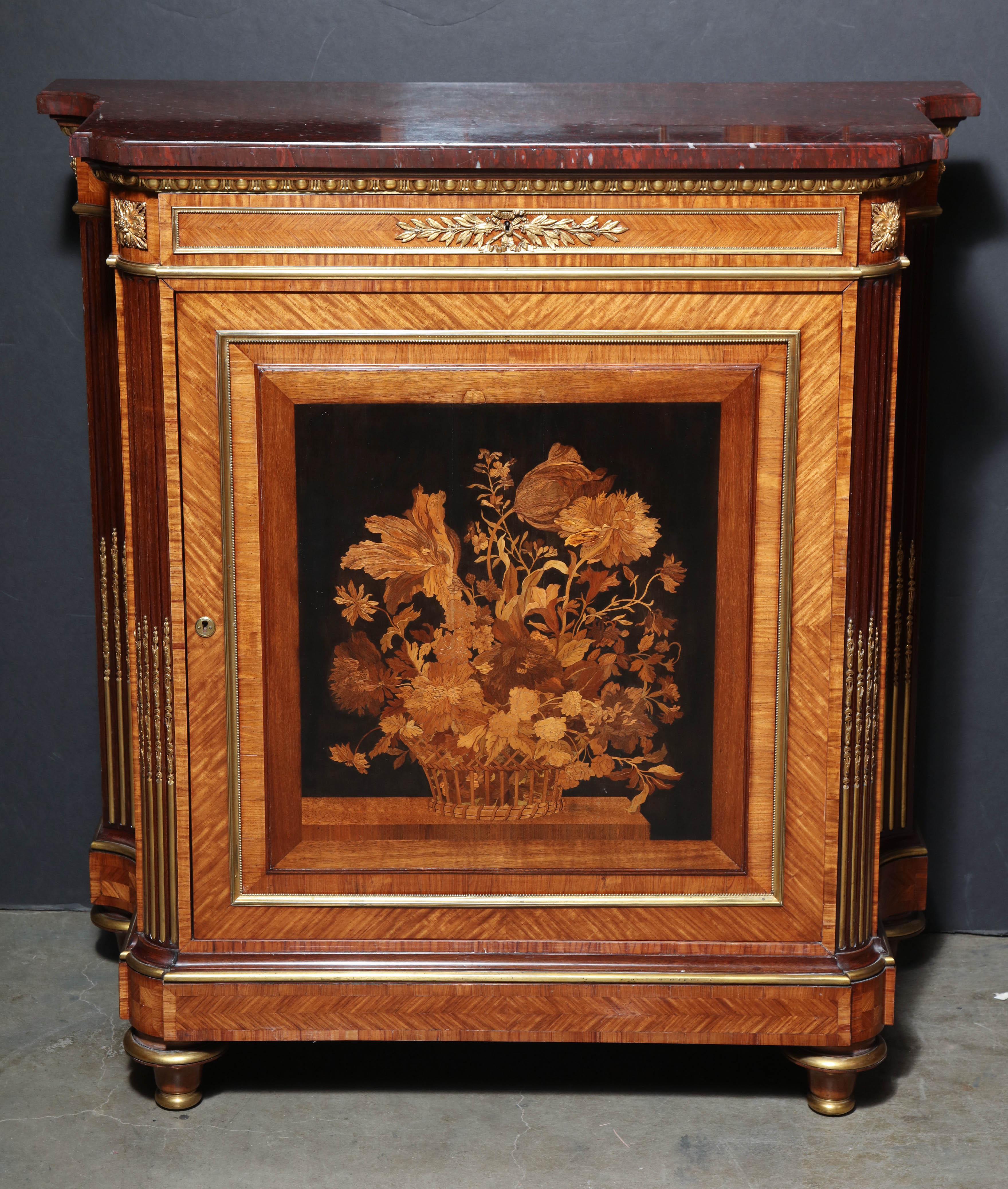 A fine and rare pair of French Louis XVI marble top bronze-mounted and marquetry inlaid side cabinets with bronze stop fluted canted corners and turned taupe feet.