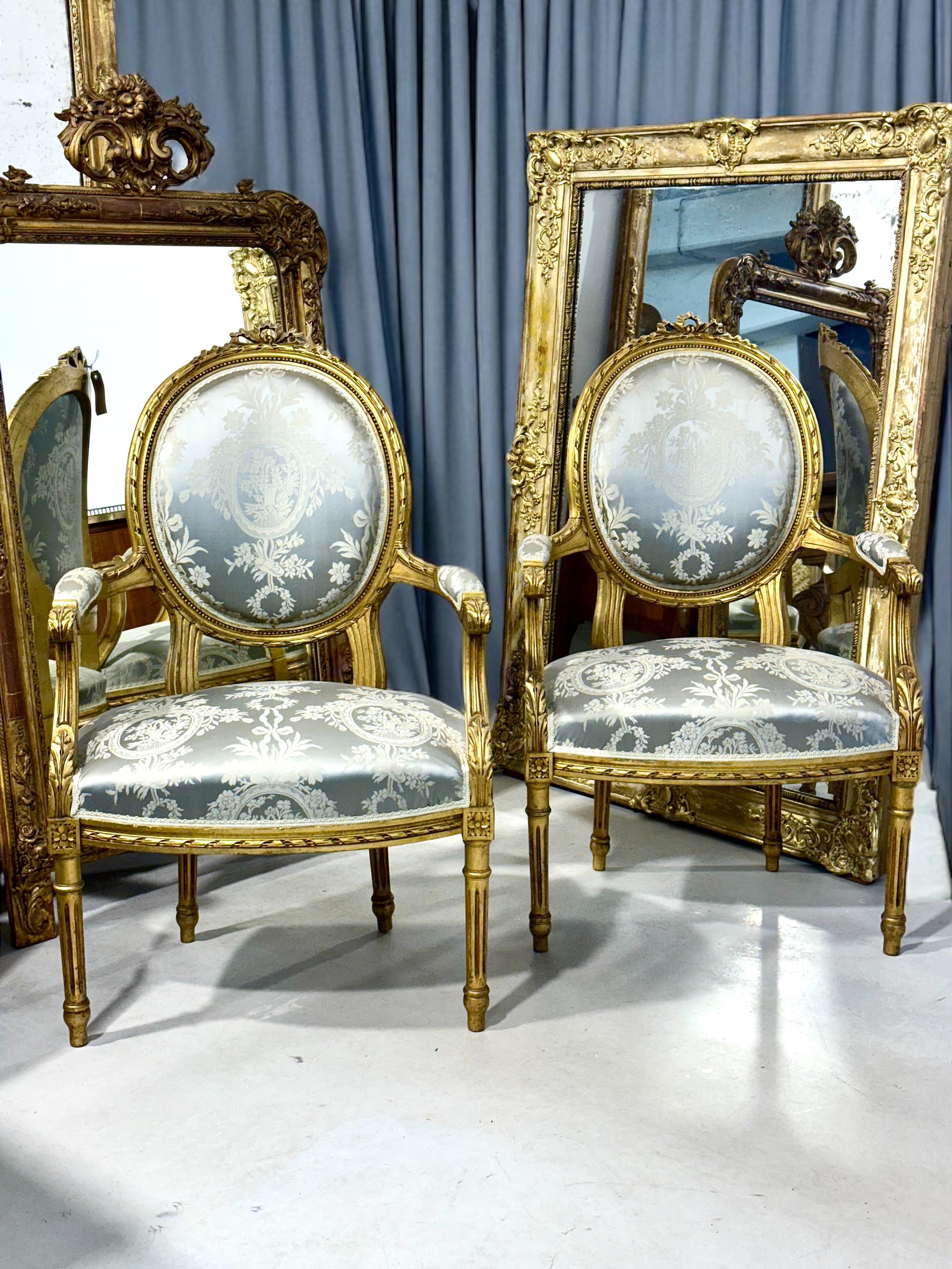 Esta elegante pareja de sillones Luis XVI con medallón capta a la perfección el refinamiento del diseño neoclásico francés del siglo XIX. Realizadas en madera dorada tallada, cada silla presenta el emblemático respaldo ovalado con medallón, sello