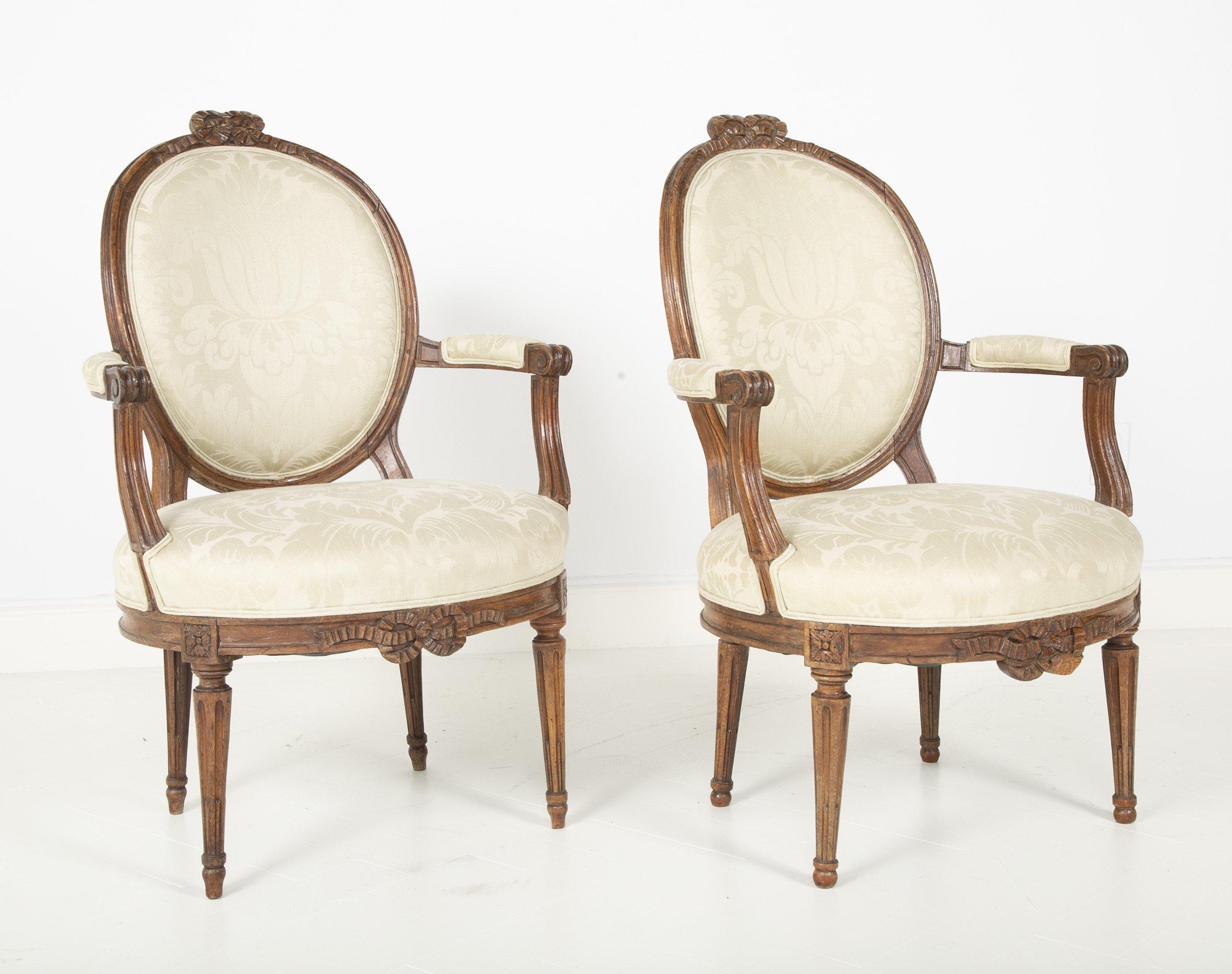 Pair of Louis XVI period oval back walnut fauteuil with stop fluted legs, bowknot and ribbon crest rail, and apron, circa 1780s.


We are proud of our long-standing partnership with George N Antiques who specializes in fine authentic antique