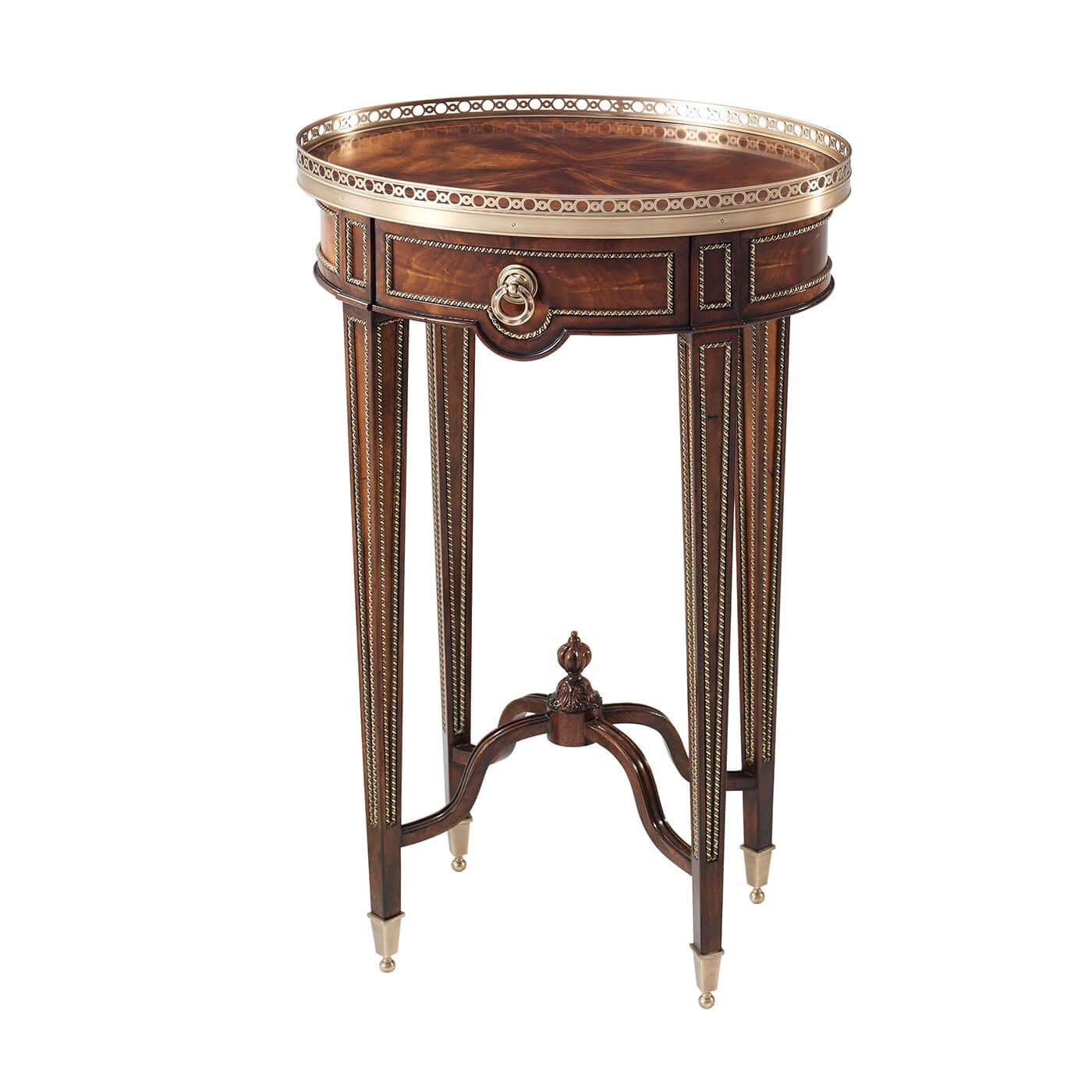 Table d'appoint ovale en acajou de style Louis XVI avec de fines montures en laiton, le plateau ovale à galerie en laiton au-dessus d'un tiroir en frise sur des pieds fuselés carrés à panneaux avec des cappings en laiton reliés par un châssis en
