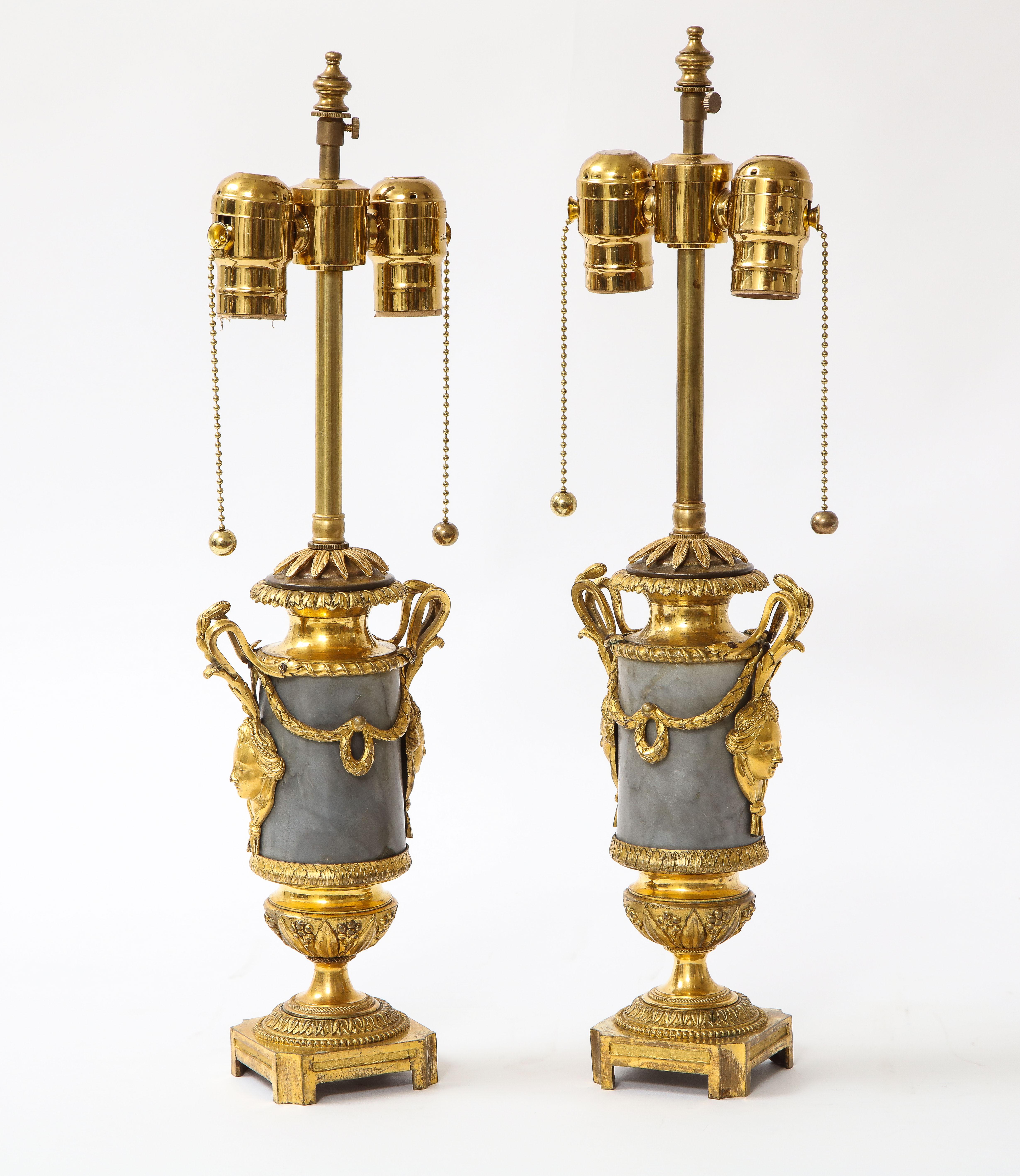 Paire de vases d'époque Louis XVI en marbre gris et noir veiné, montés en bronze de Dore et transformés en lampes. Chacun d'entre eux est magnifiquement réalisé avec un corps cylindrique en marbre gris et noir veiné sculpté à la main, avec des