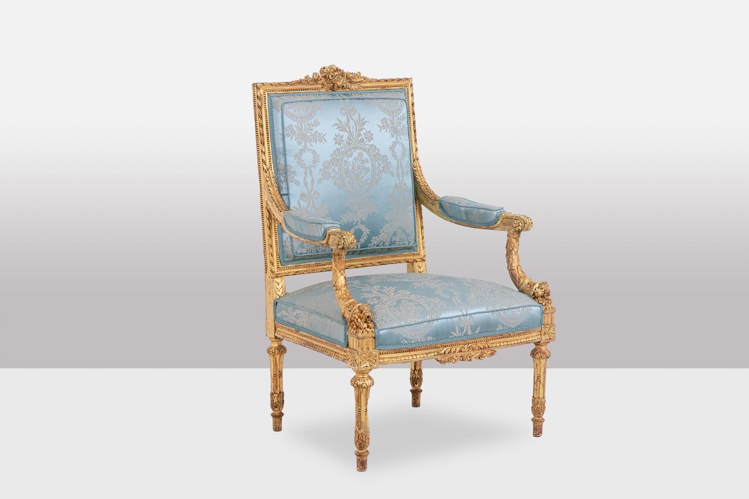 Pair of Louis XVI style armchairs in gilded and carved wood, “Marie-Antoinette” model, the top of the back decorated with a basket, garlands and flowers and its frame decorated with a finely beaded frieze, the armrests with cuffs set back from the