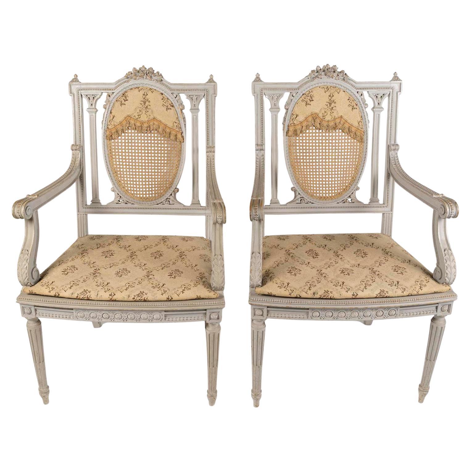 Paire de fauteuils de style Louis XVI, en bois sculpté et peint et Cane, 19e siècle.