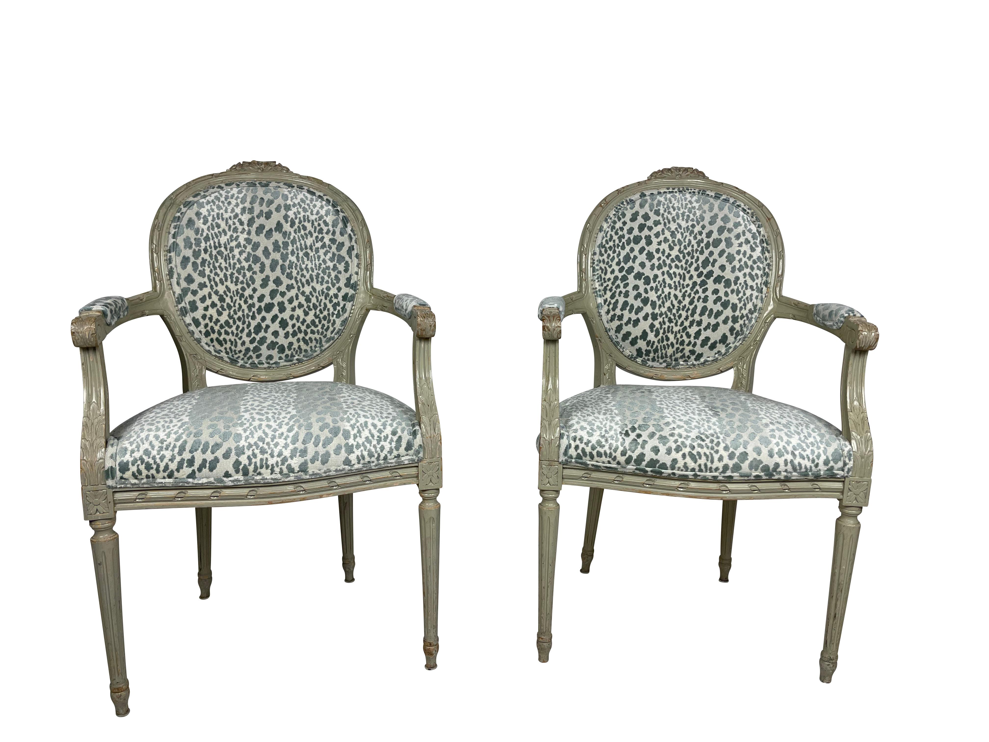 These lovely Louis XVI grey/green painted armchairs are original to the Waldorf Astoria Hotel, circa 1930-1940. They have been lovingly restored and reupholstered with a blue/green animal print velvet. They are nicely carved with floral and bow