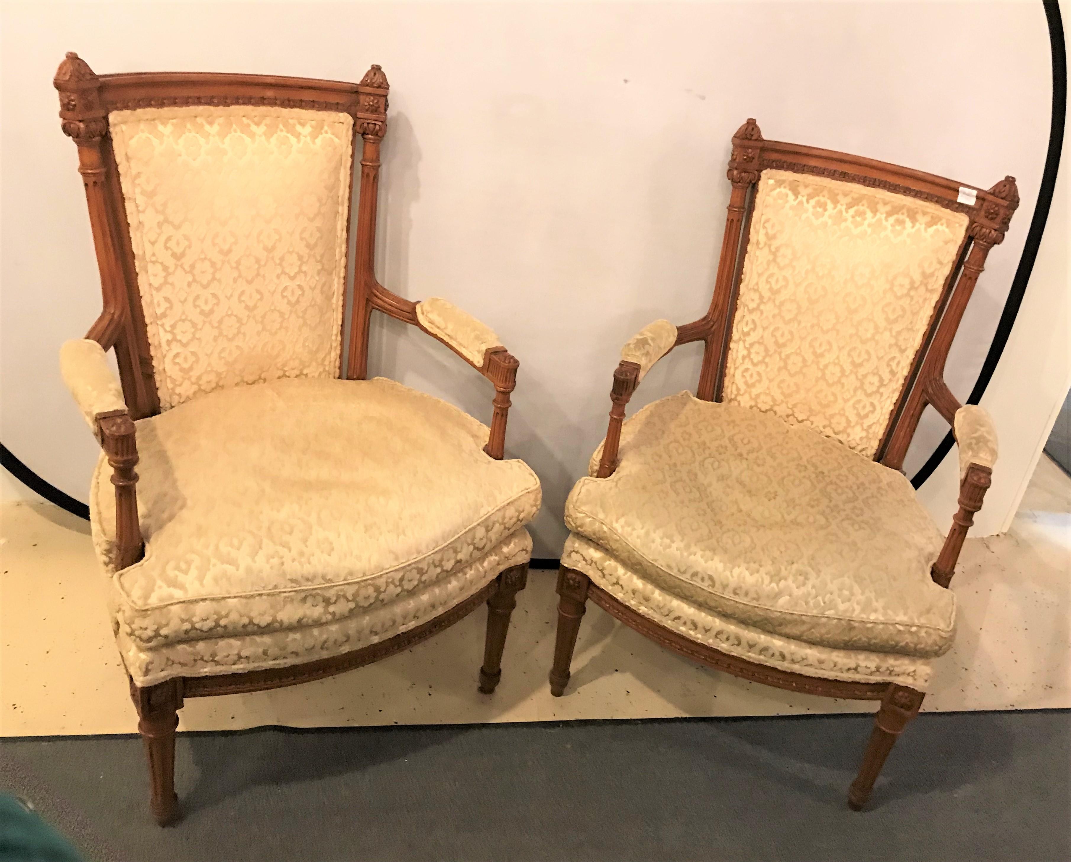 A pair of Louis XVI style bergere chairs or armchairs. Each in a nice clean upholstered frame with fine carvings.