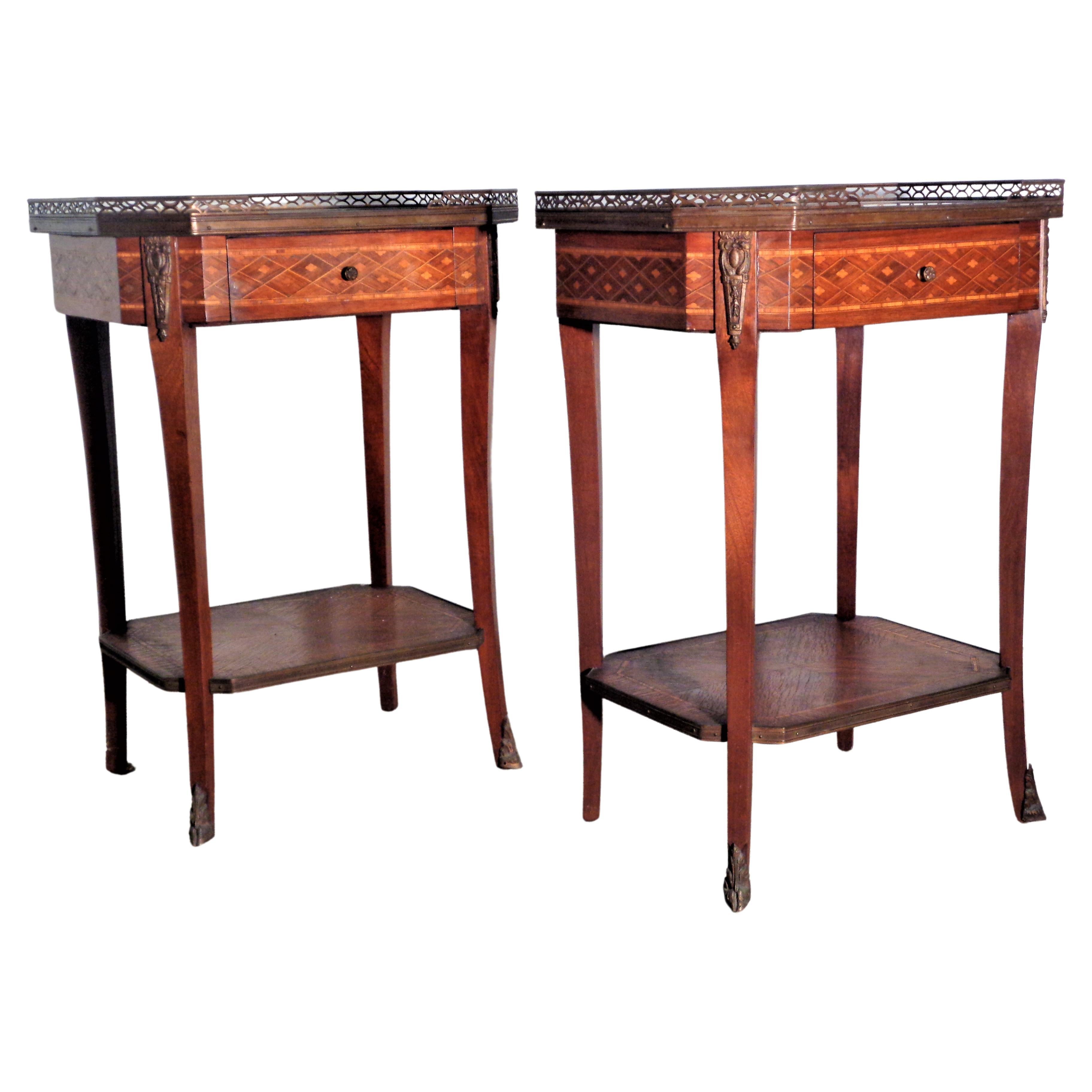 Pair of Grosfeld House parquetry inlaid Louis XVI style bouillotte tables with rouge marble tops / brass galleries at top and bottom shelf / bronze mounts at sides / bottom of feet / dovetailed drawers. Grosfeld's - Chicago, New York, Los Angeles