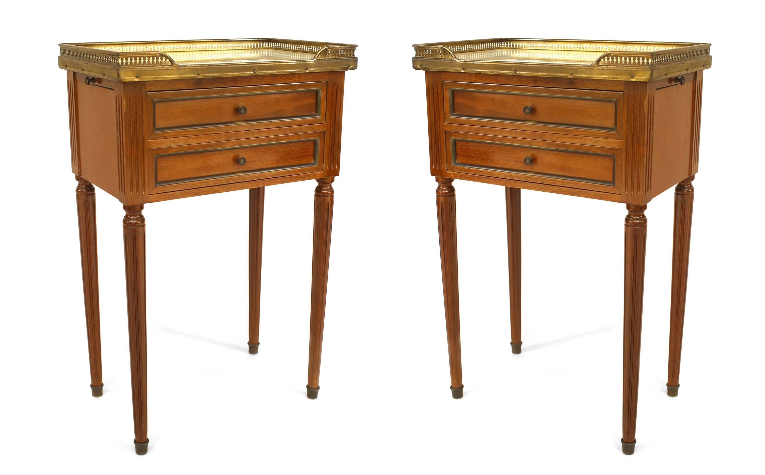Pair of French Louis XVI-style walnut low end tables with brass trim and 2 drawers with a white marble top and filigree gallery. (PRICED AS Pair)

