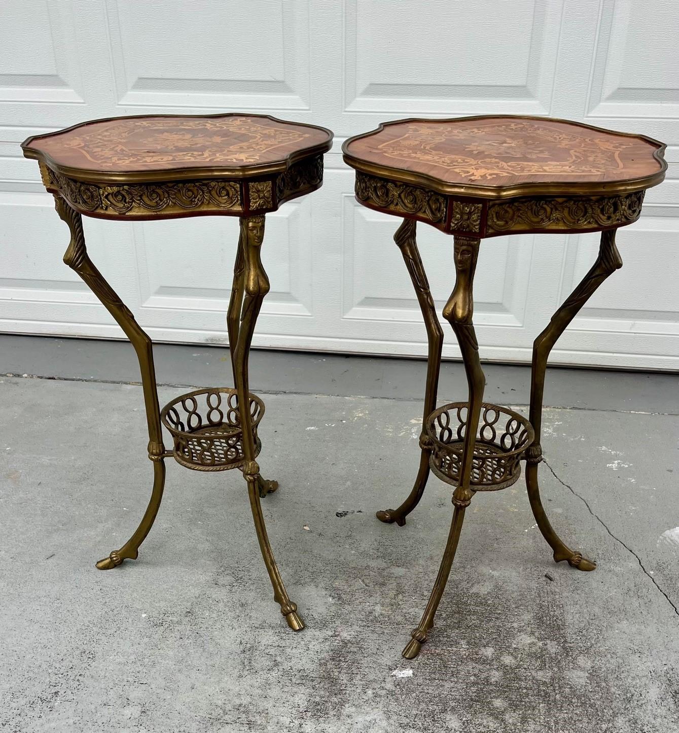 Pair of most elegant French 20th century Louis XVI style Gueridons side tables. The base is a solid bronze tripod pedestal supporting an openwork bronze basket with cast female heads terminating in hoofed feet. The fine marquetry top, inlaid with