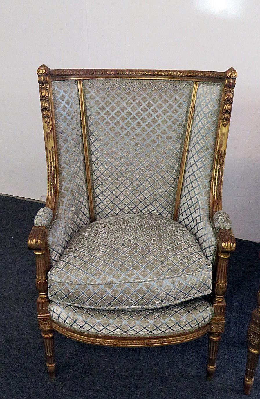 Pair of Louis XVI style bronze mounted wing back chairs, in the manner of Forest, with textured upholstery.