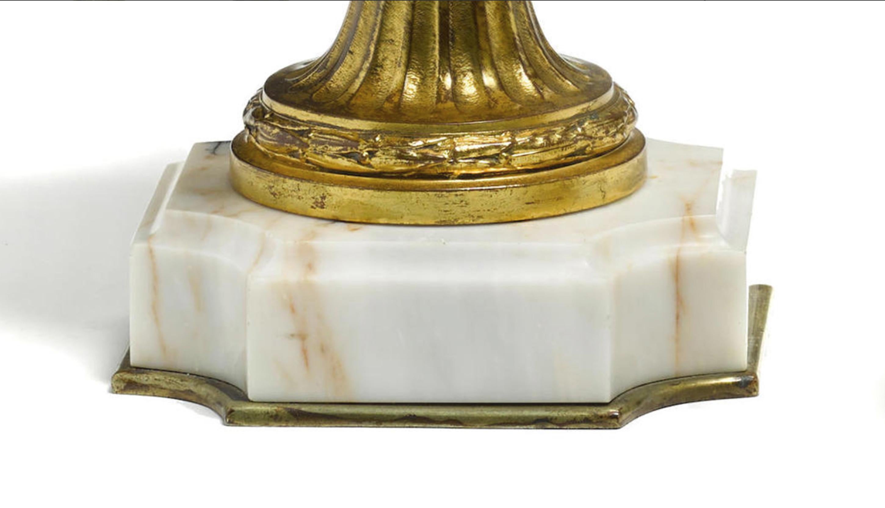 Extremely fine pair of 19th century French Louis XVI style gilt and patinated bronze on marble base.

Each urn is surmounted by an ormolu lid, over a neck mounted scrolling foliate appliqué, above a shaped body with gilt masks, above a gilt bronze