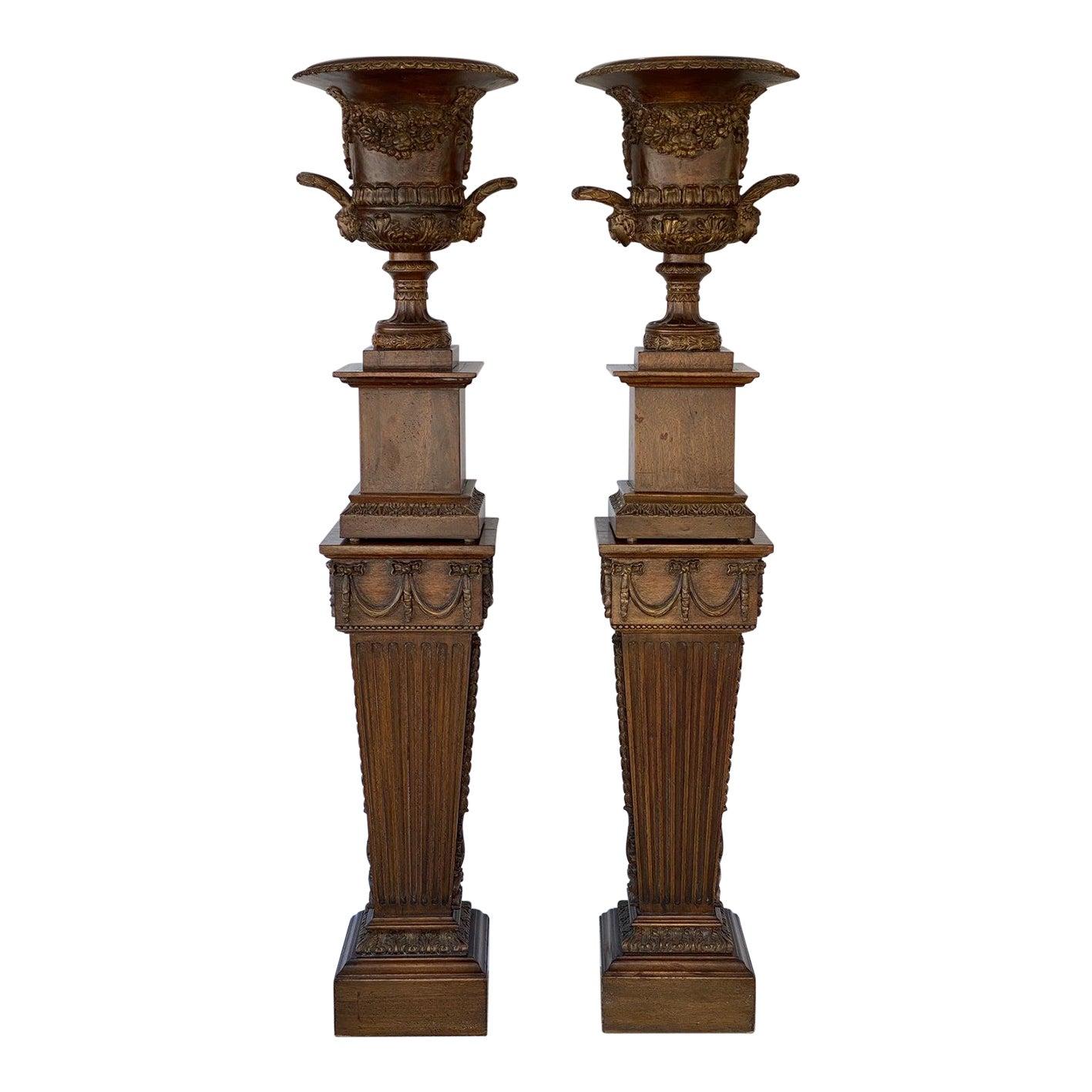 This stylish pair of hand-carved wood campara urns on stands date to the 1930s and were acquired from a home decorated by the iconic interior designer and antiuqe dealer John Regas.

Note: The overall dimensions are 71