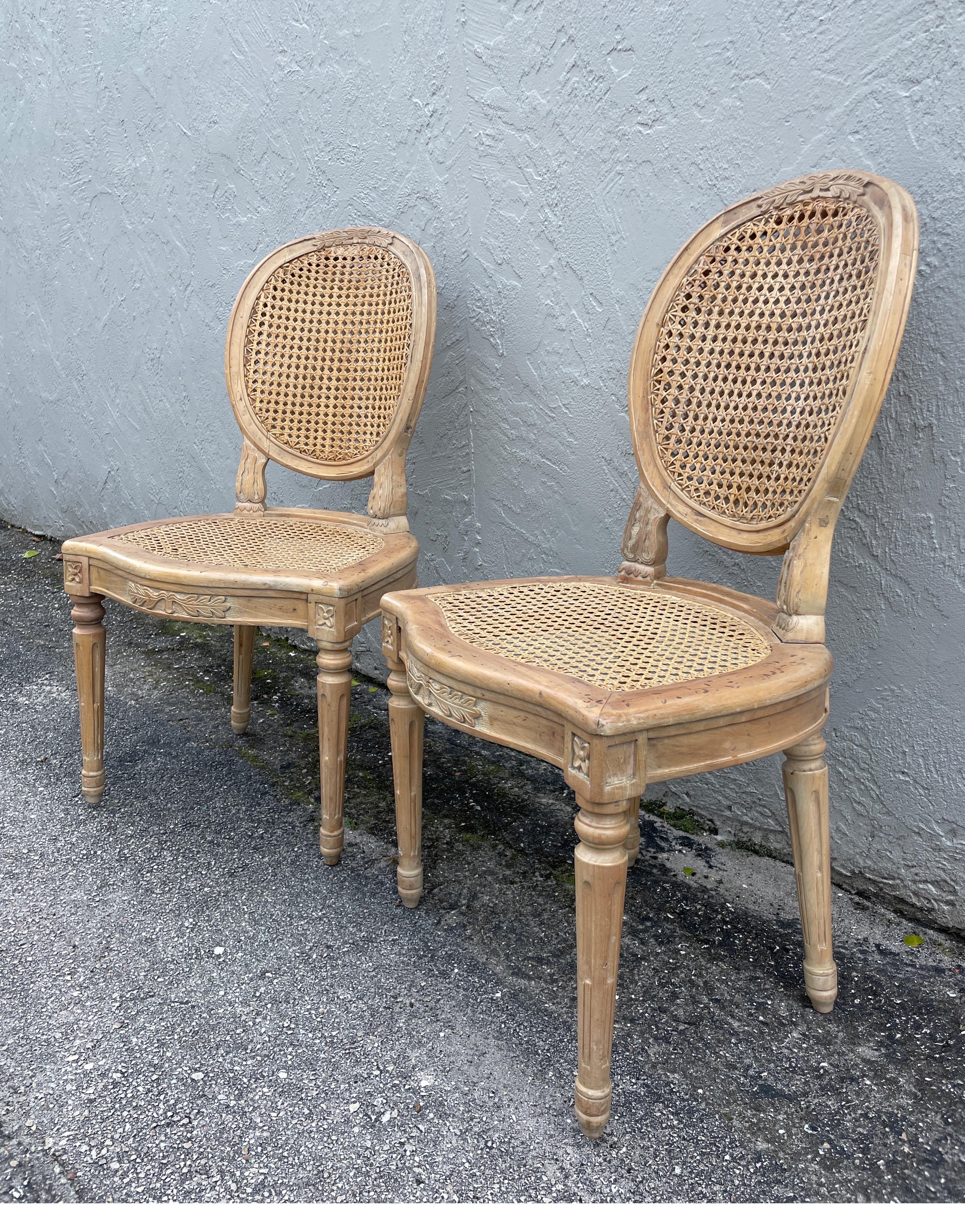 Vintage Paar Beistellstühle im Louis XVI-Stil. Die Oberfläche hat eine helle, natürliche Farbe mit einem leichten Hauch von Weiß. Die Sitzfläche ist mit Rohrstöcken versehen und die ovale Rückenlehne ist mit zwei Handstöcken versehen. Sehr gut