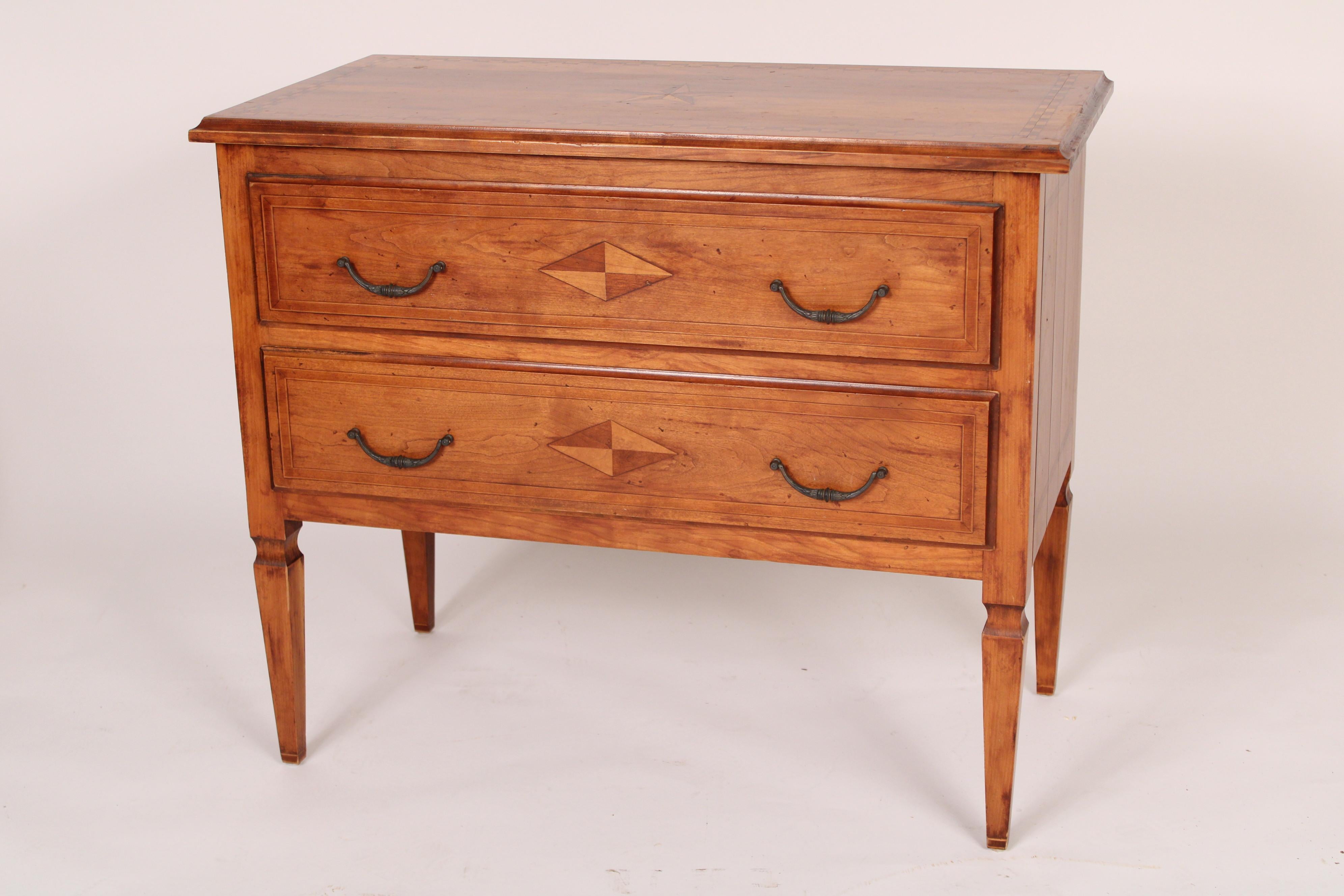 Pair of Louis XVI style fruit wood chests of drawers, late 20th century. With a thumb molded overhanging top with parquetry inlaid borders and central star inlay over two drawers with patinated metal drawer pulls and diamond inlay, resting on square