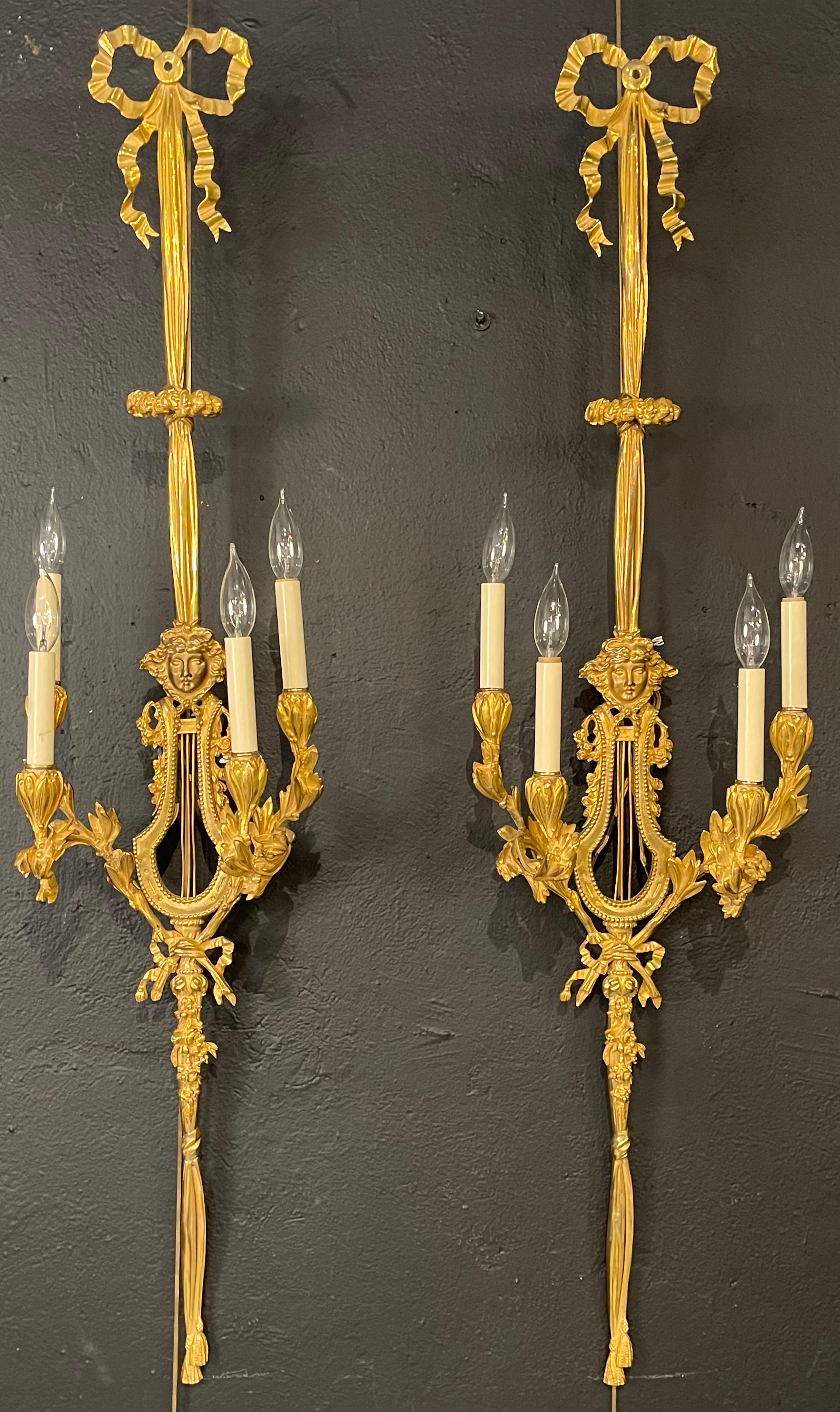 Pair of Louis XVI style doré bronze wall sconces. This stunning pair of monumental ribbon and tassel form wall sconces are sure to take your breath away. Straight from a Greenwich CT mansion bearing the finest of gilt bronze come this large and