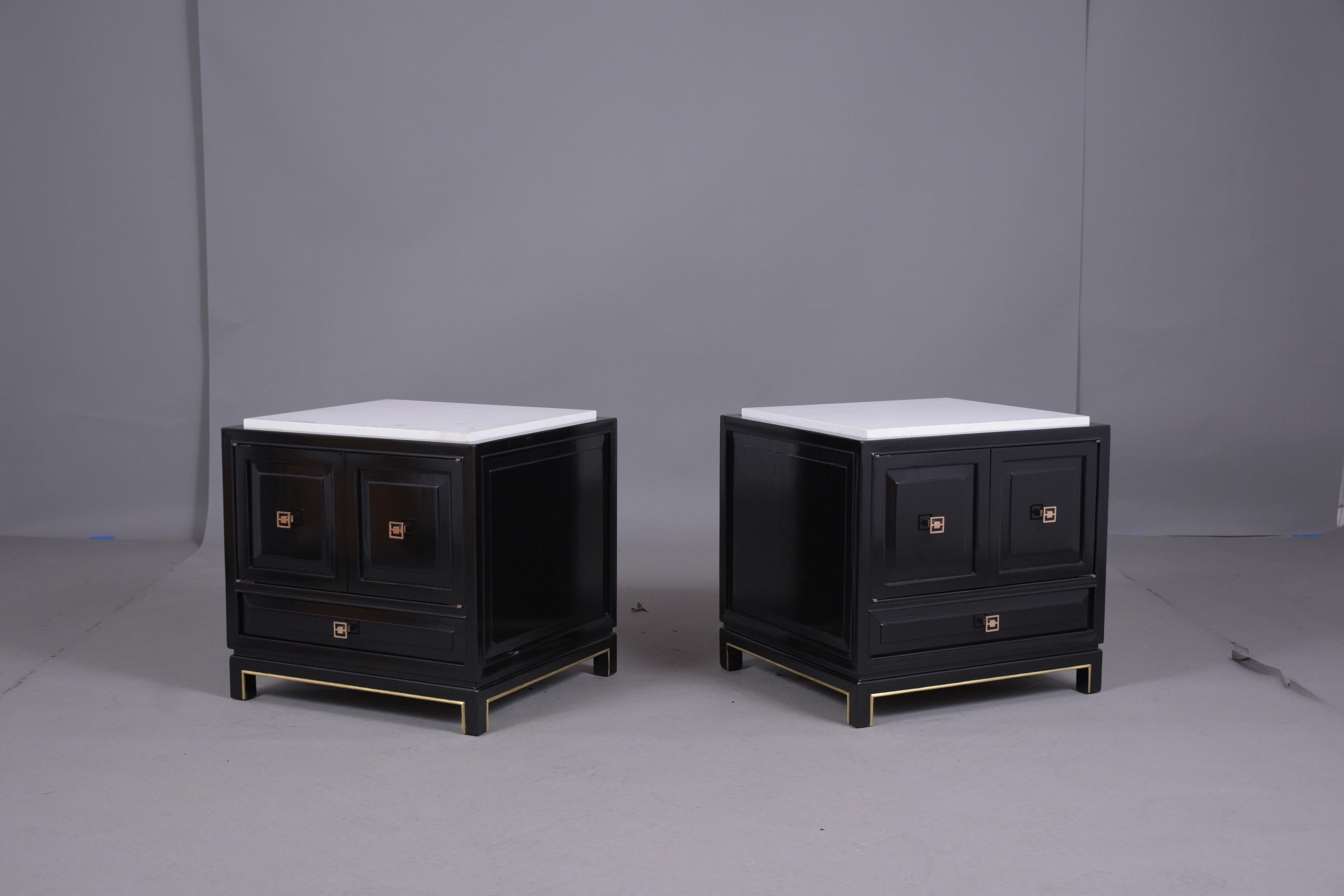 An elegant pair of Louis XVI-style nightstands made out of mahogany wood that has been professionally restored by our team of expert craftsmen and features new white marble tops. These end tables are newly ebonized with a lacquer finish, gilt