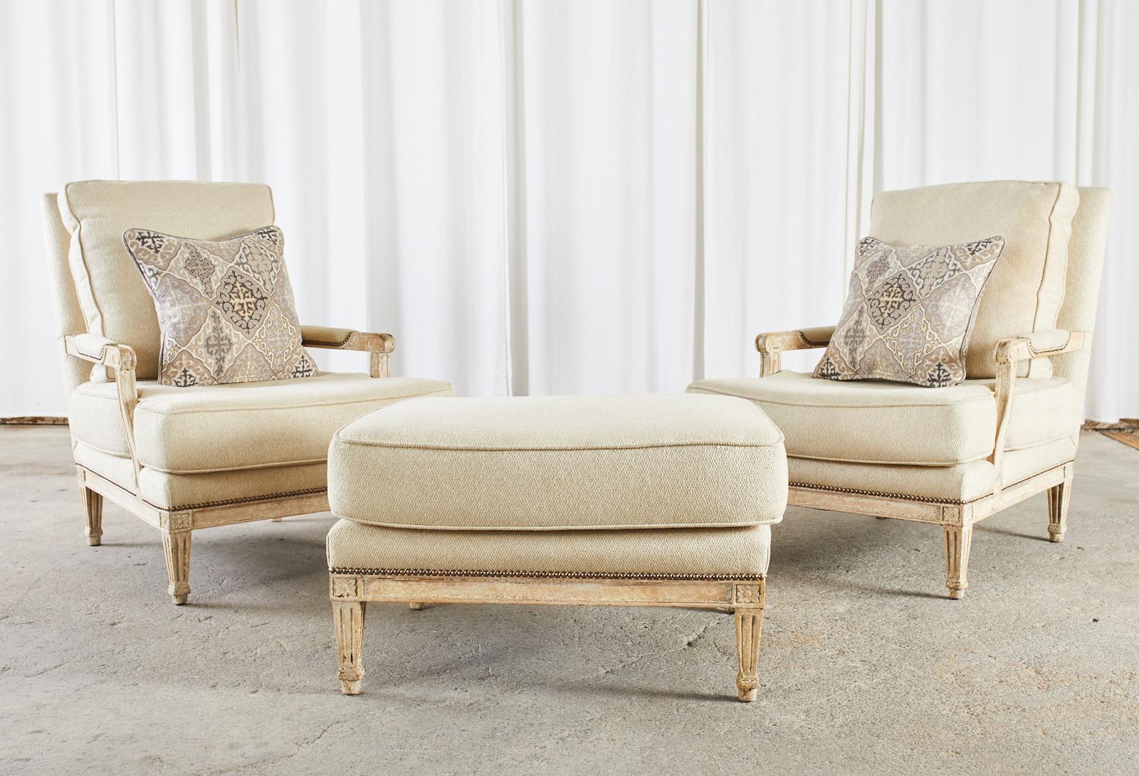 Amazing pair of French Louis XVI style fauteuils, armchairs, or lounge chairs with an ottoman. The large chairs are made in the fauteuil a la Reine style with classic square backs and generous seats. Crafted from beech frames with an intentionally