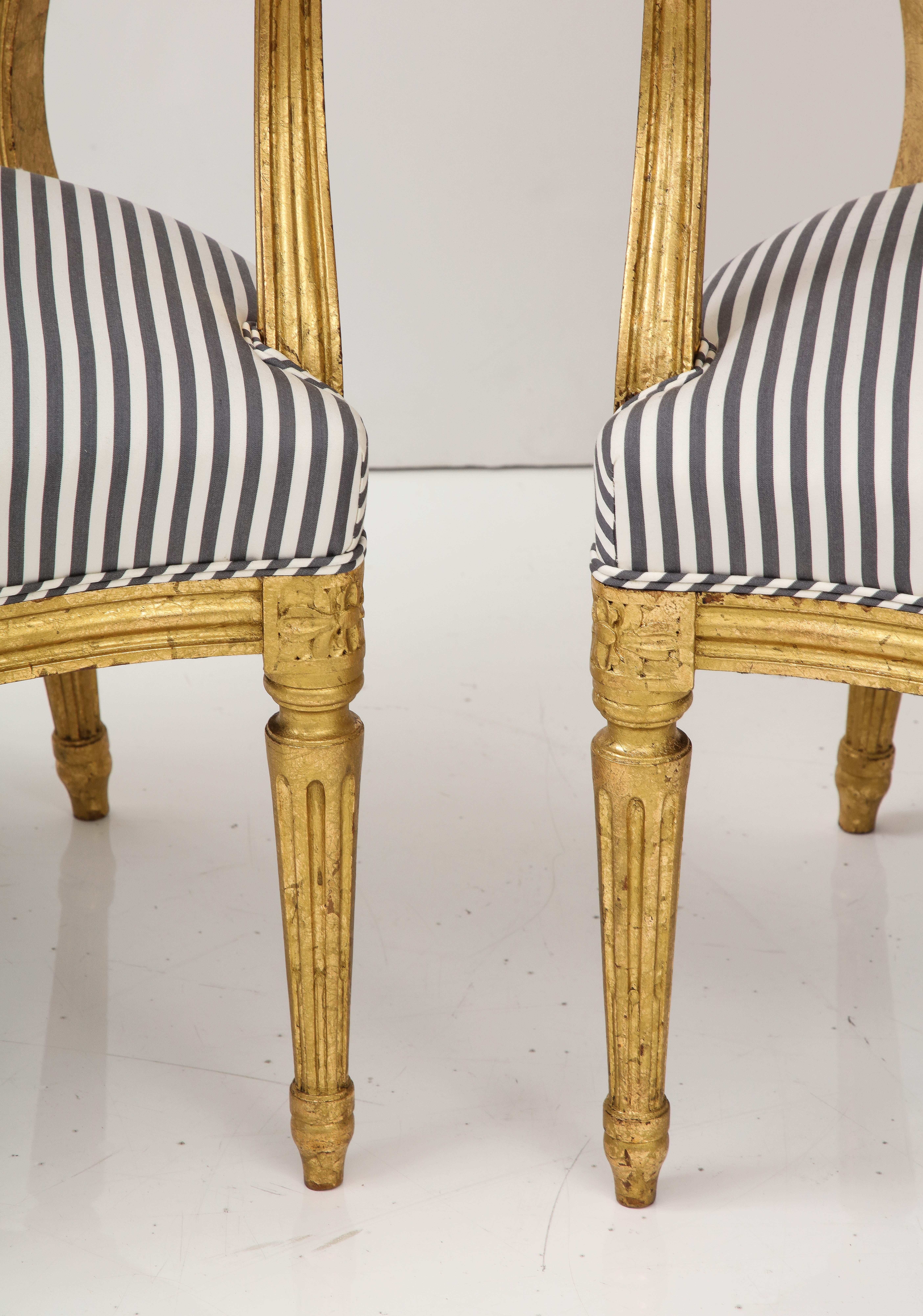 Bei diesem schicken Paar vergoldeter Sessel im Louis-XVI-Stil trifft Alt auf Neu.  Wir lieben die schlichte Eleganz des Louis XVI-Stils, und diese Stühle weisen viele der für diesen Stil charakteristischen Details auf - eine ovale Rückenlehne,