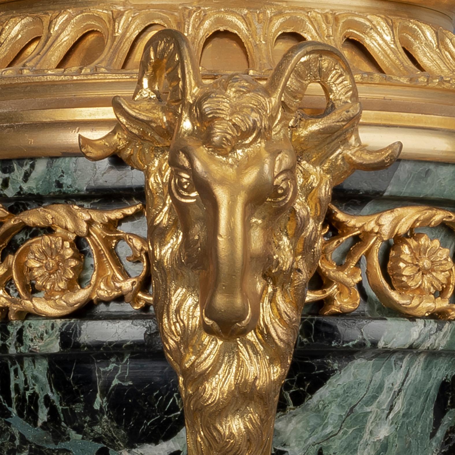 Une paire de Cassolettes de style Louis XVI en bronze doré et marbre.

Chacune avec une urne et un couvercle en marbre Verde antico ornés de guirlandes feuillagées et d'un fleuron en forme de baie, supportés par une colonne en spirale entourée