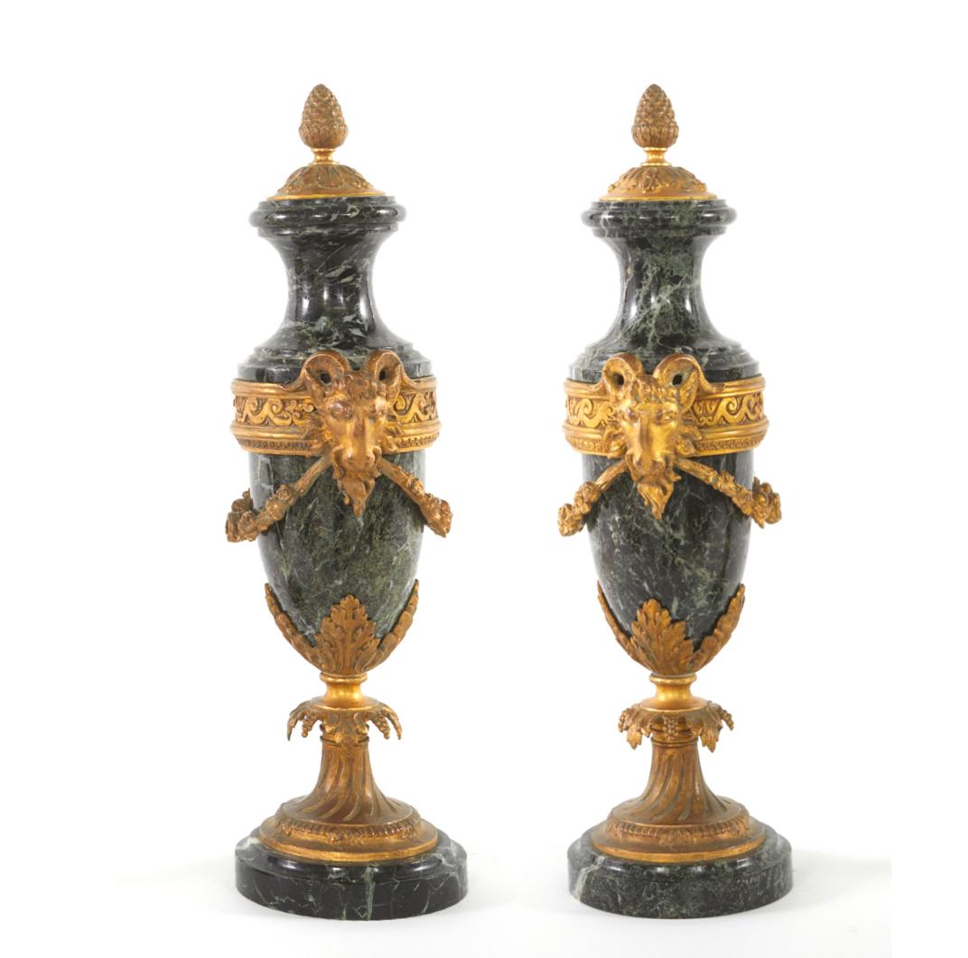 Mid 19th century pair of Louis XVI style gilt bronze mounted and ormulu Cassolettes / decorative urns. Each casollette featuring a covered embellisment foliate garlands, berried finial with ram's side details. Measures: Each one stands about 17