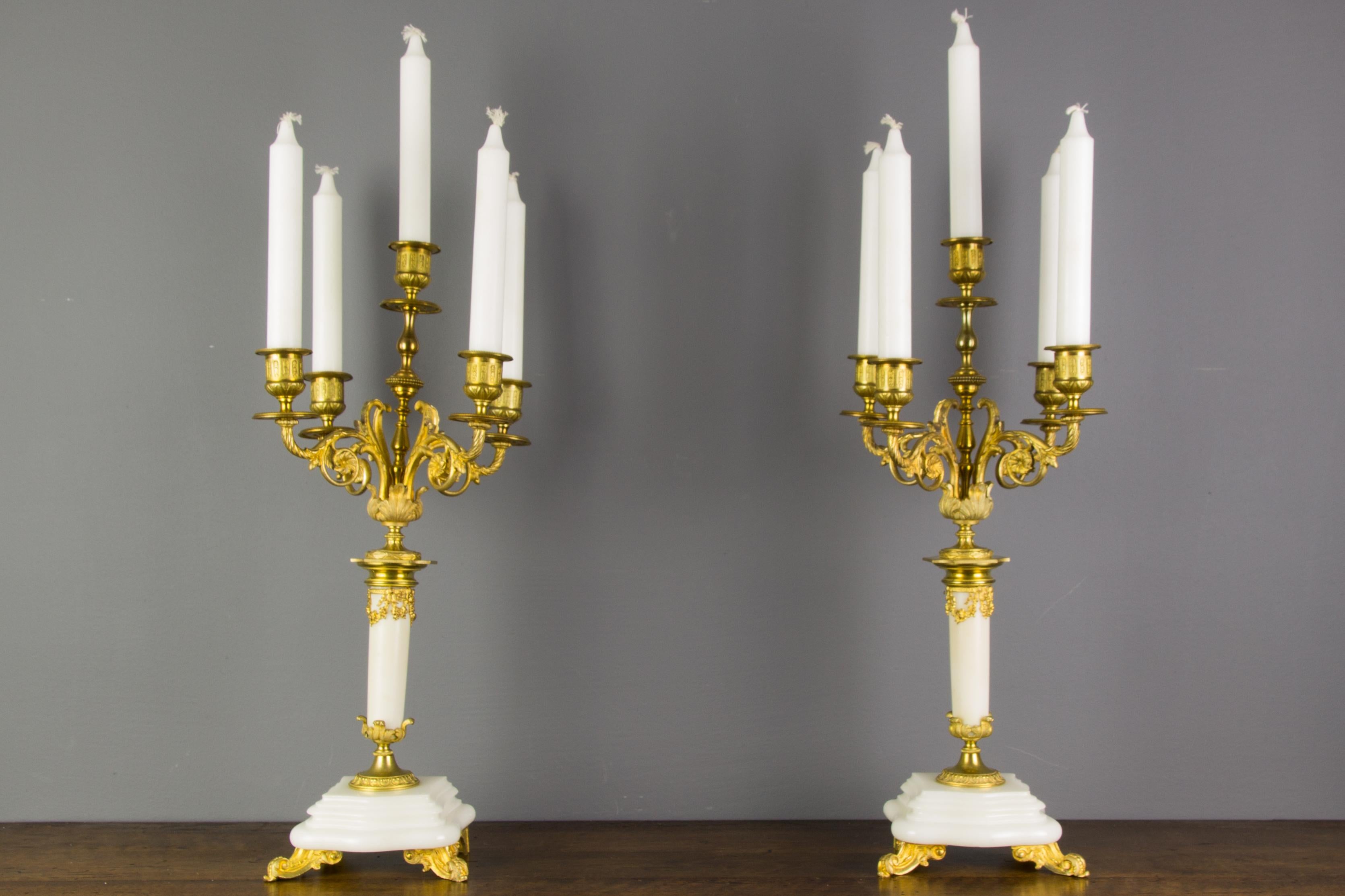 Beautiful pair of white marble and gilt bronze five-light candelabras. The marble is wonderfully sculptured in lovely curved detail. Each gilt bronze arm is decorated with an interior ‘C’ scroll design with floral rosettes amid acanthus leaves.