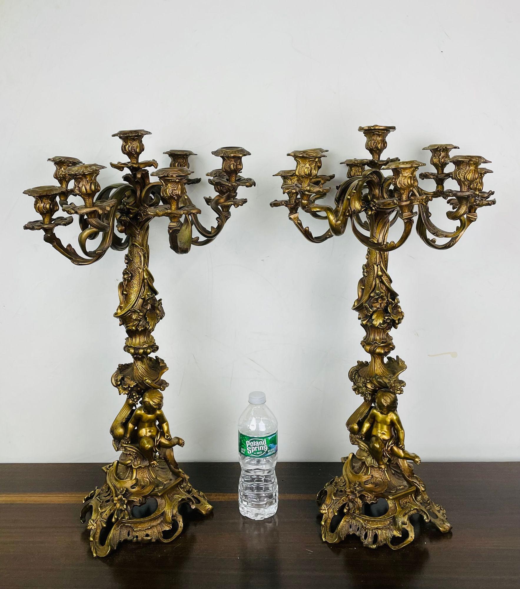 Pair of Louis XVI Style Gilt Bronze candelabra, Cherub Florentine Form
A large and impressive pair of Candelabra, each having a large group of nine arms for candlesticks on a center column form pedestal with a Cherub holding the stem. The pair on