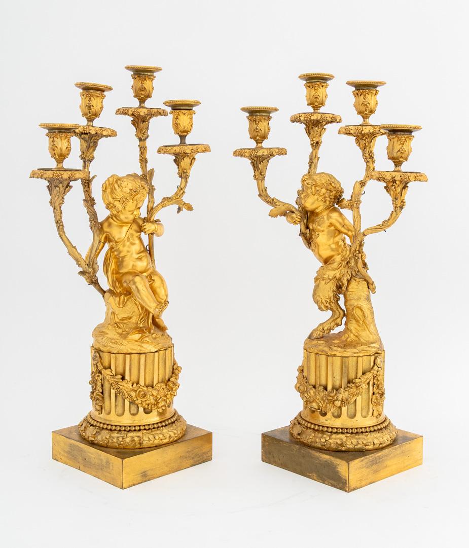 Pareja de candelabros de cuatro luces de bronce dorado estilo Luis XVI, 
según modelos de Claude Michel Clodion y Louis Felix de La Rue, finales del siglo XIX. 22