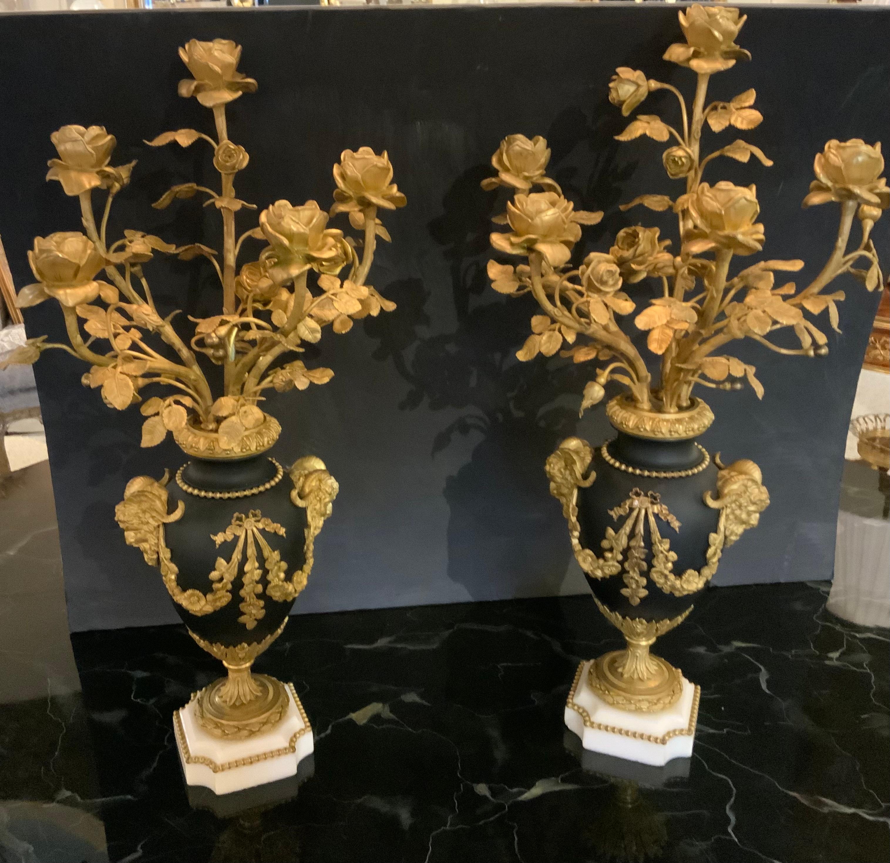 Pair of exceptional candelabra in the Louis XVI Style each
With five lights and of vasiform centering ribbon-tied blossoming garlands flanked by bearded satyr masks with scrolling horns 
Beneath a bearded collar and a fruiting leaf tip rim