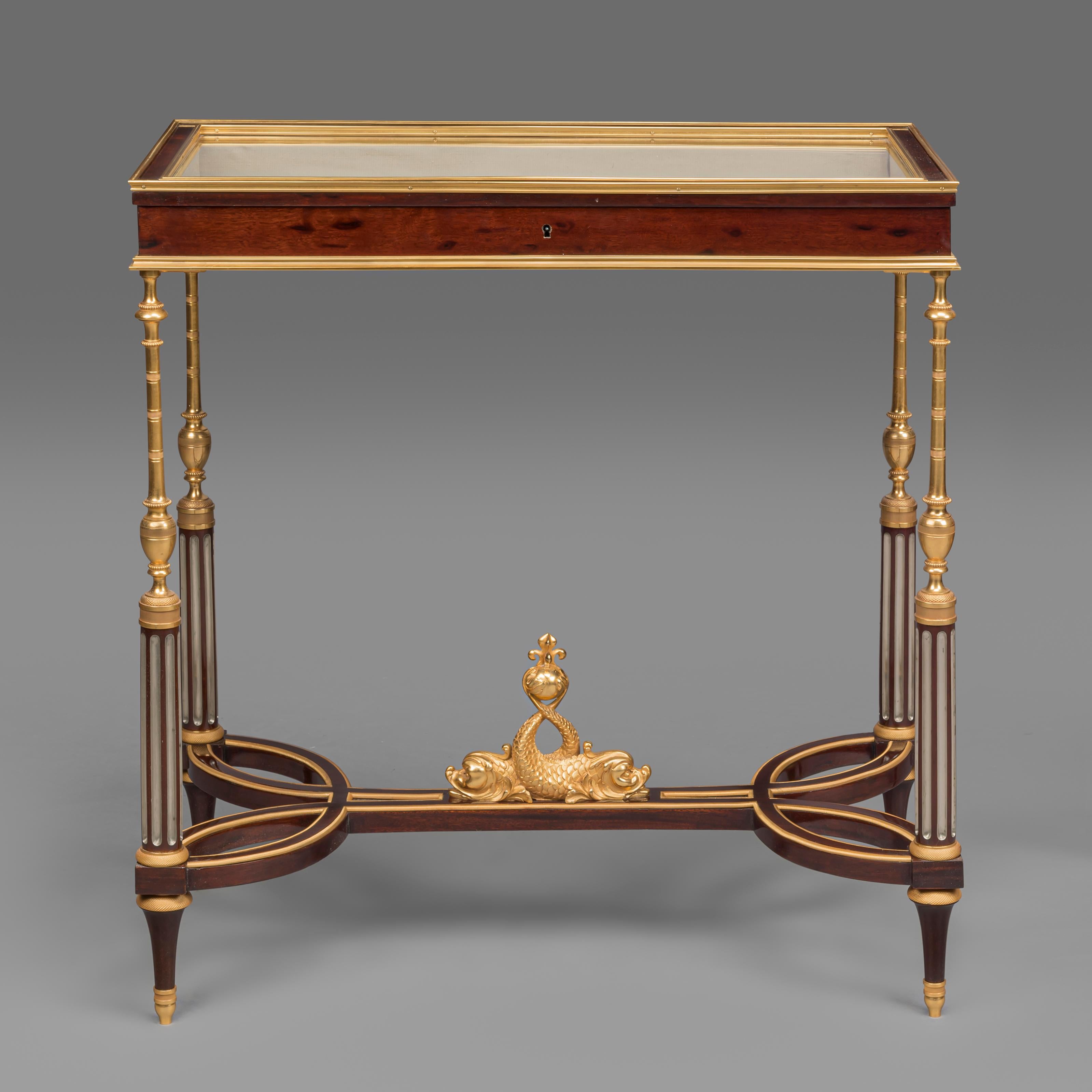 A Rare Pair of Louis XVI Style Gilt-Bronze Mounted Vitrine Tables In The Manner of Weisweiler, by Georges-François Alix.

This rare pair of mahogany vitrine tables each have a hinged rectangular glass top opening to shallow velvet lined interiors. 