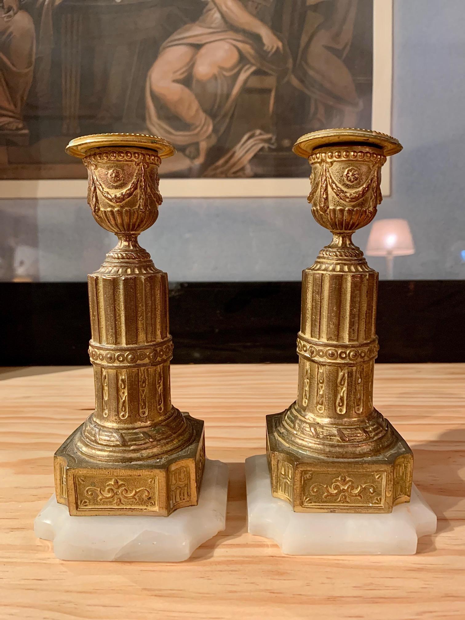 A pair of Louis XVI style candlesticks, in gilt metal in the central part of the column that rests on an alabaster base.