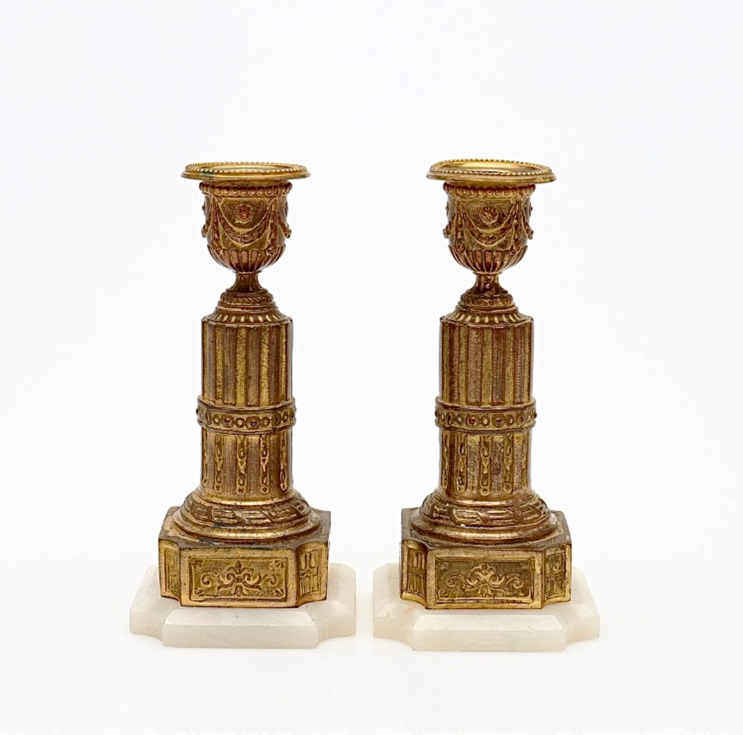 Paire de chandeliers de style Louis XVI en métal doré et albâtre