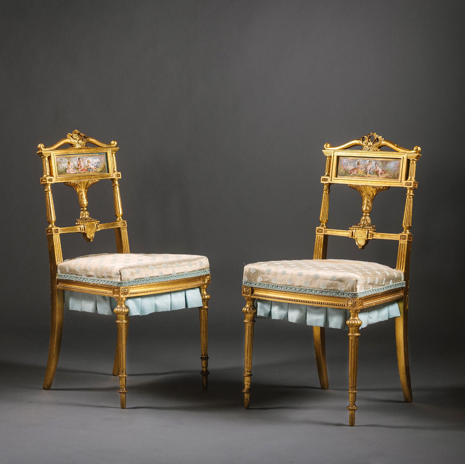 A Pair of Louis XVI Style Giltwood and Sèvres-Style Porcelain Mounted Salon or Bedroom Chairs

These charming chairs are delicately carved and adorned with attributes of love. The top rail is carved as a bow centred by a ribbon. The Sèvres style