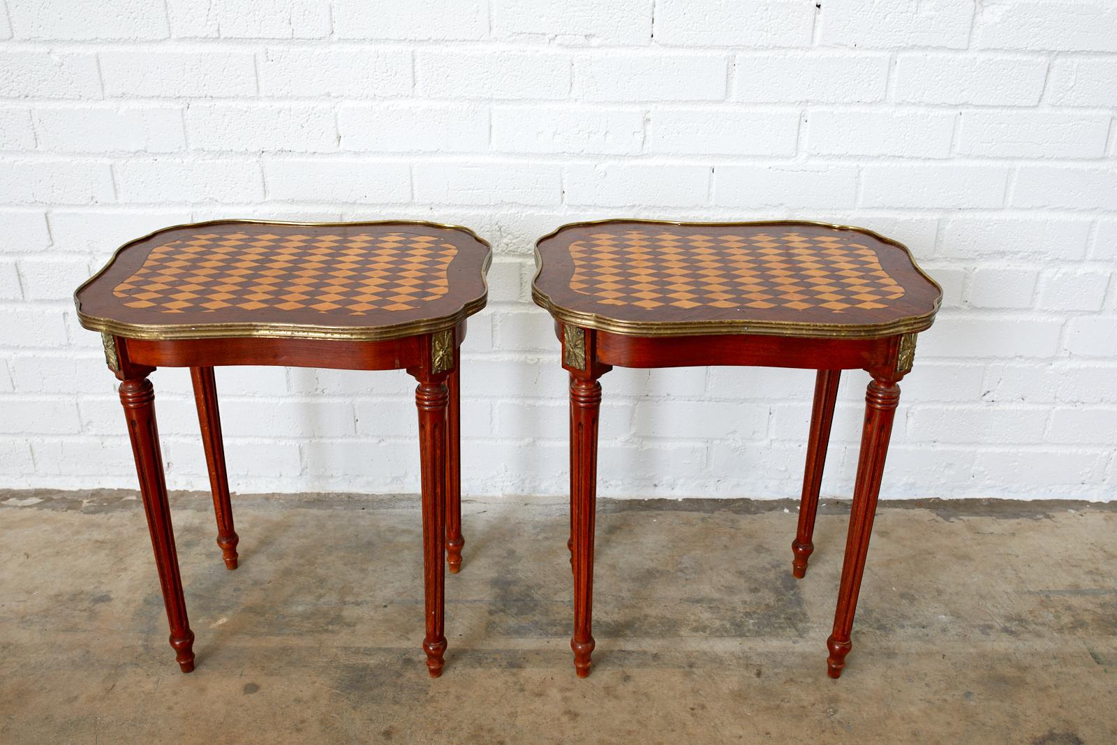 Impressive pair of French drink tables or side tables featuring a marquetry inlay top with diamond harlequin pattern design. Beautifully crafted with a bronze mounted galleried edge with reeded detail. The tables have scalloped edges with a