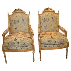 Pair of Louis XVI style leaf gilded armchairs with yellow silk upholstery.
