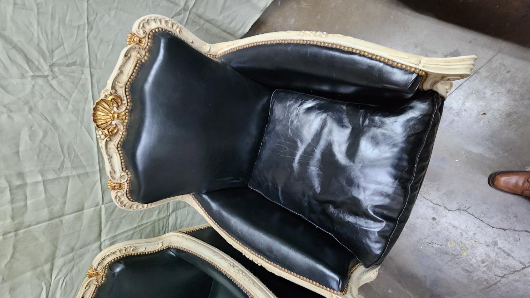 Questo annuncio presenta una coppia di sedie francesi in stile Luigi XVI che sono state rivestite in pelle nera.