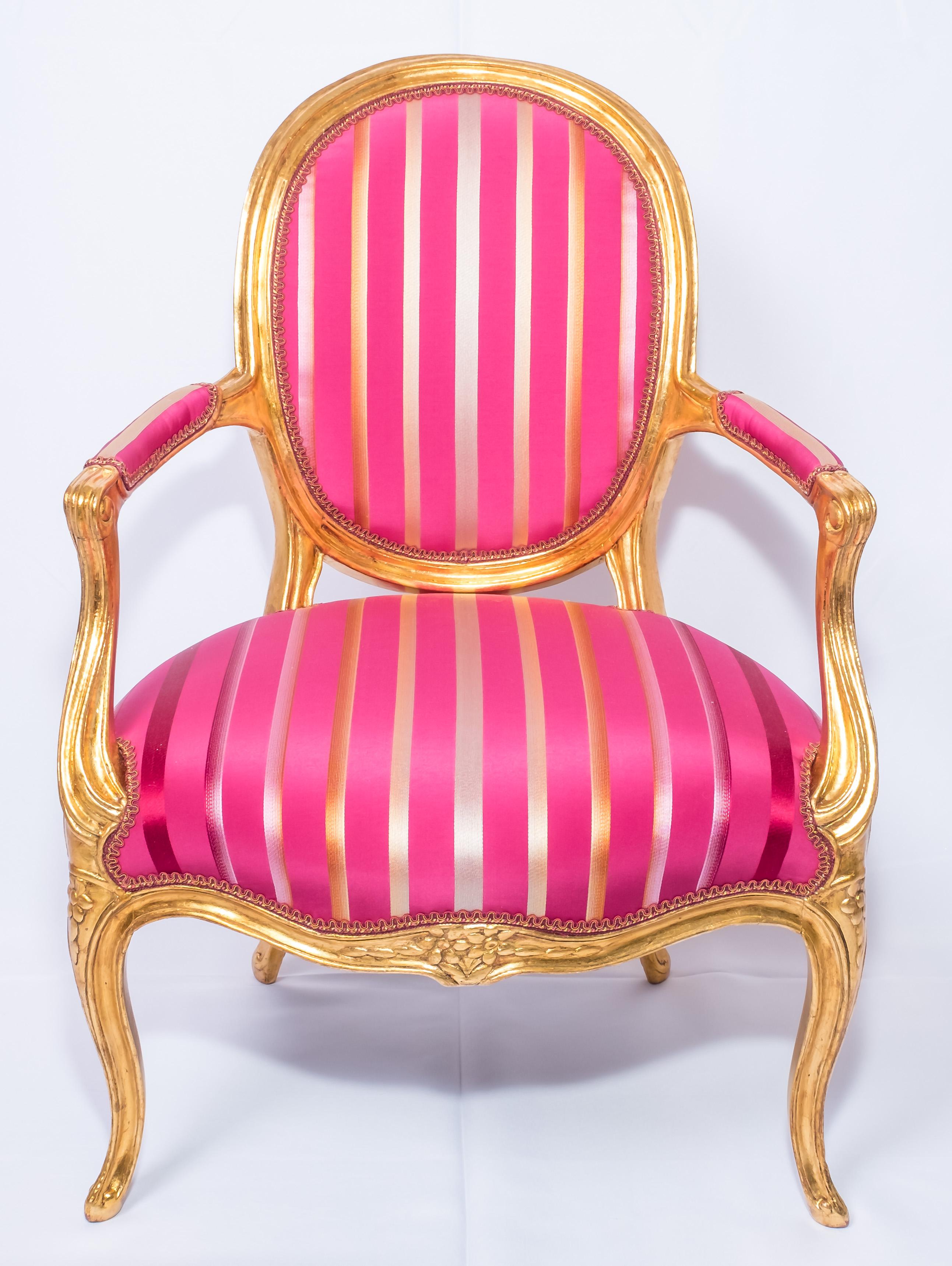 Original hand carved wood frame from the early 20th century, newly gilded with 24-karat gold leaves.
Newly upholstered with delicate and luxurious magenta color stripped fabric.
Measures: Height 87 cm, width 60.5 cm, depth 50 cm.

Ref.