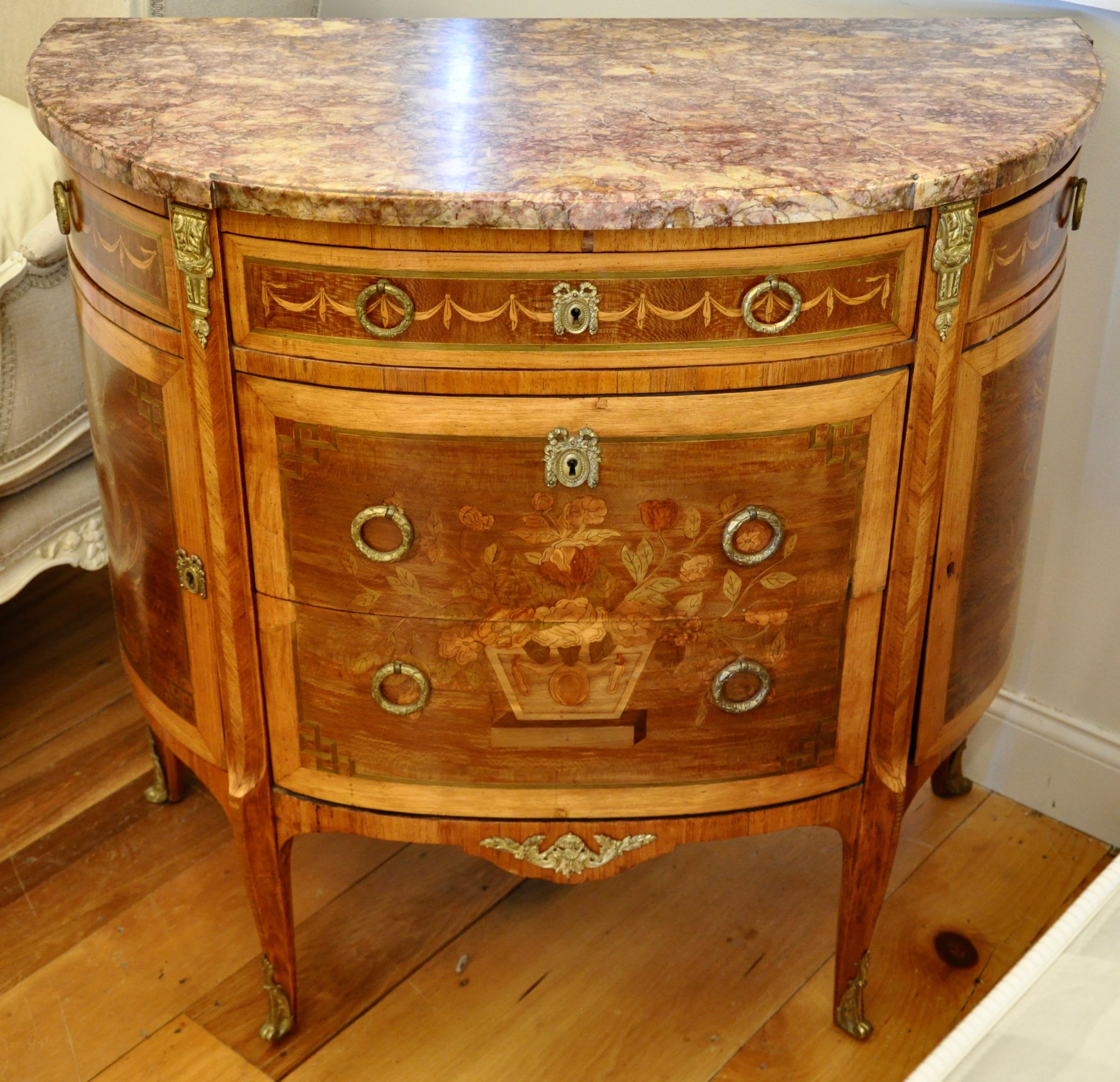 Pair of exquisite Louis XVI style commodes

-- Demilune
-- Original marble tops
-- Neoclassical
-- Kingwood, fruitwood and walnut.