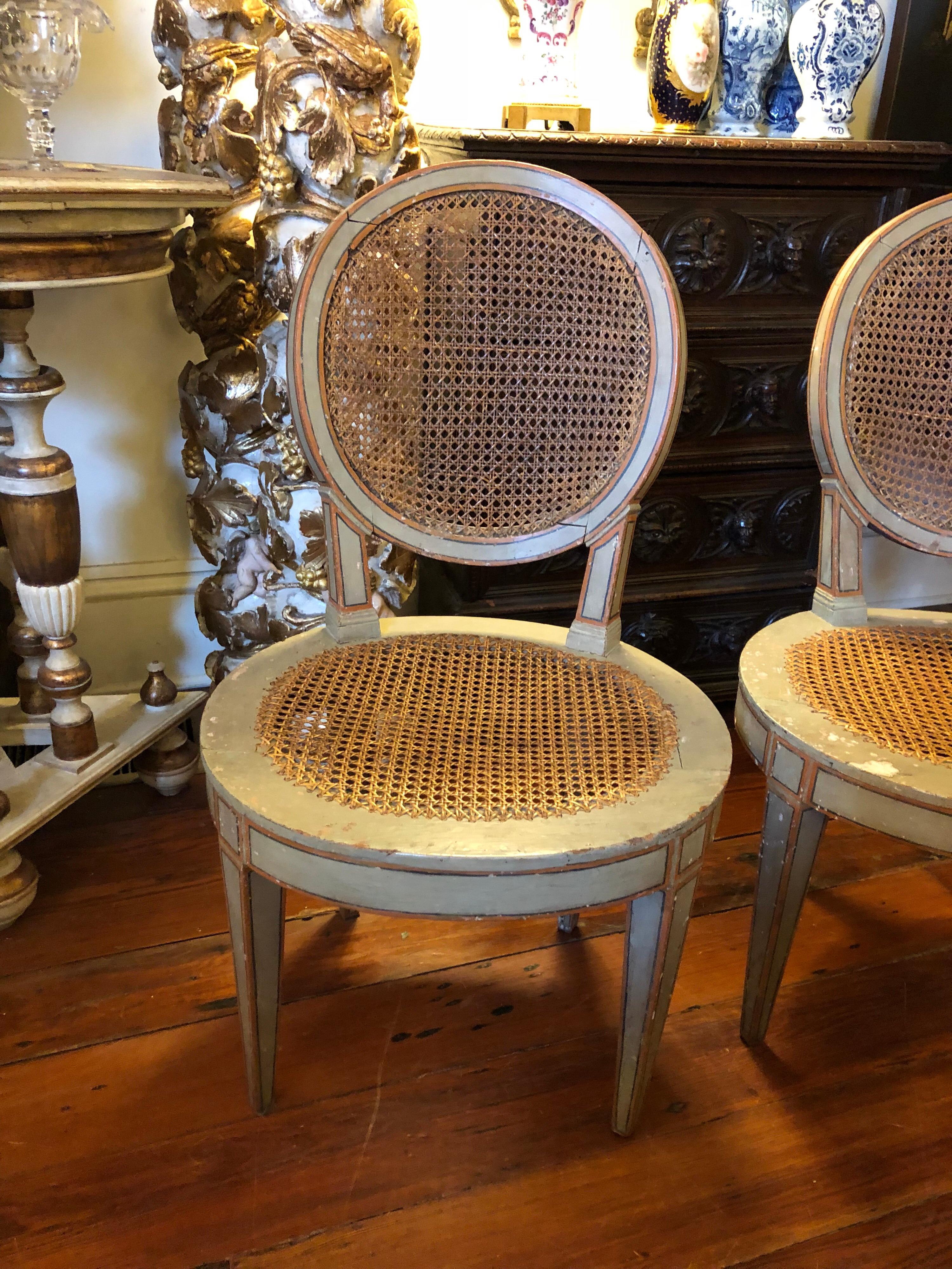 Pair of LouisXVI style Italian pained oval back chairs with cane back and seats.