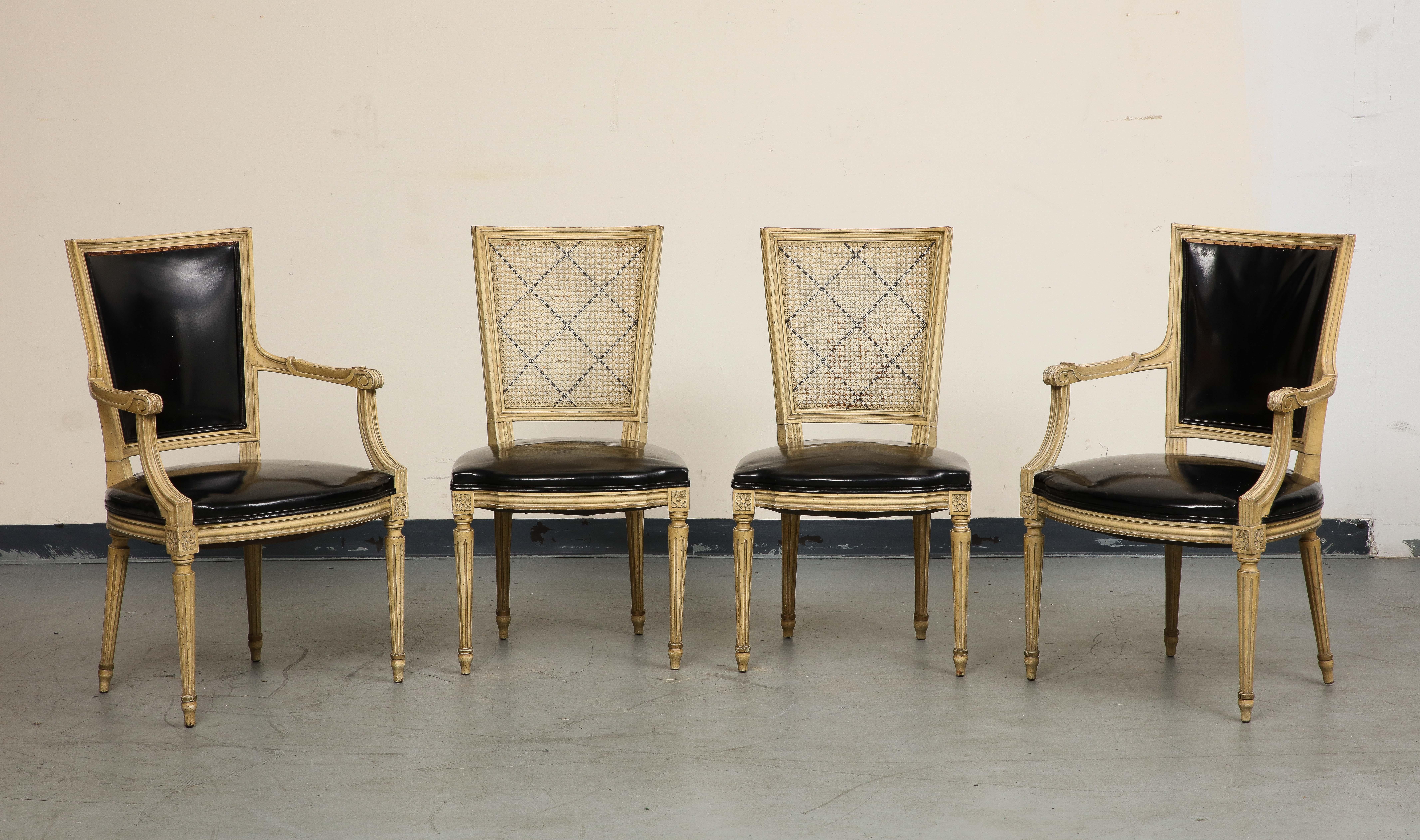 A lovely set of four (4) midcentury French chairs, circa 1940, in the Louis XVI style. One pair of armchairs with faux black leather seats and backs is partnered with a pair of side chairs with elegant cane backs. 

Armchair Dimensions: 37